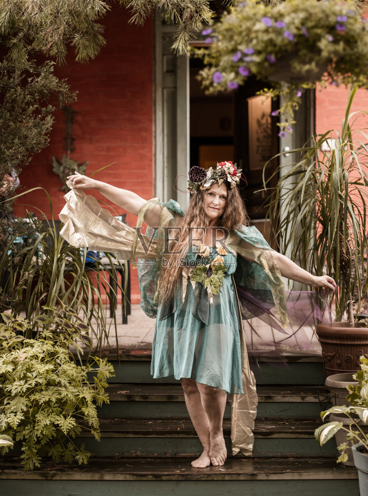 老妇人在花园里装扮成仙女照片摄影图片