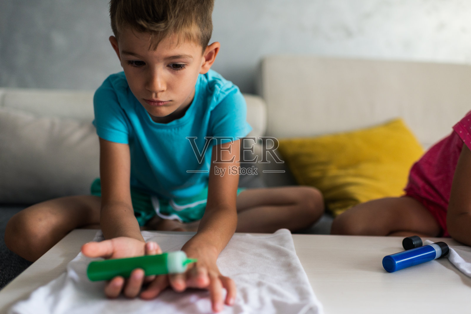 男孩在材料上作画照片摄影图片