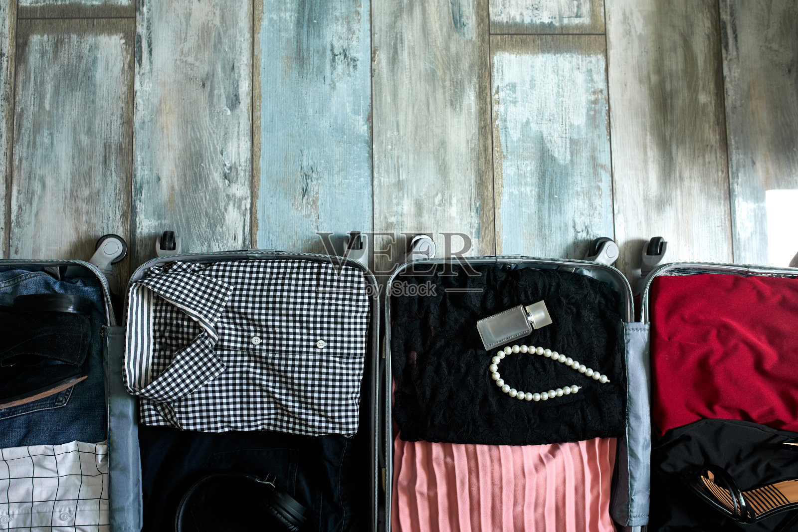 打开带有服装和配饰的情侣行李箱，旅行和关系概念照片摄影图片