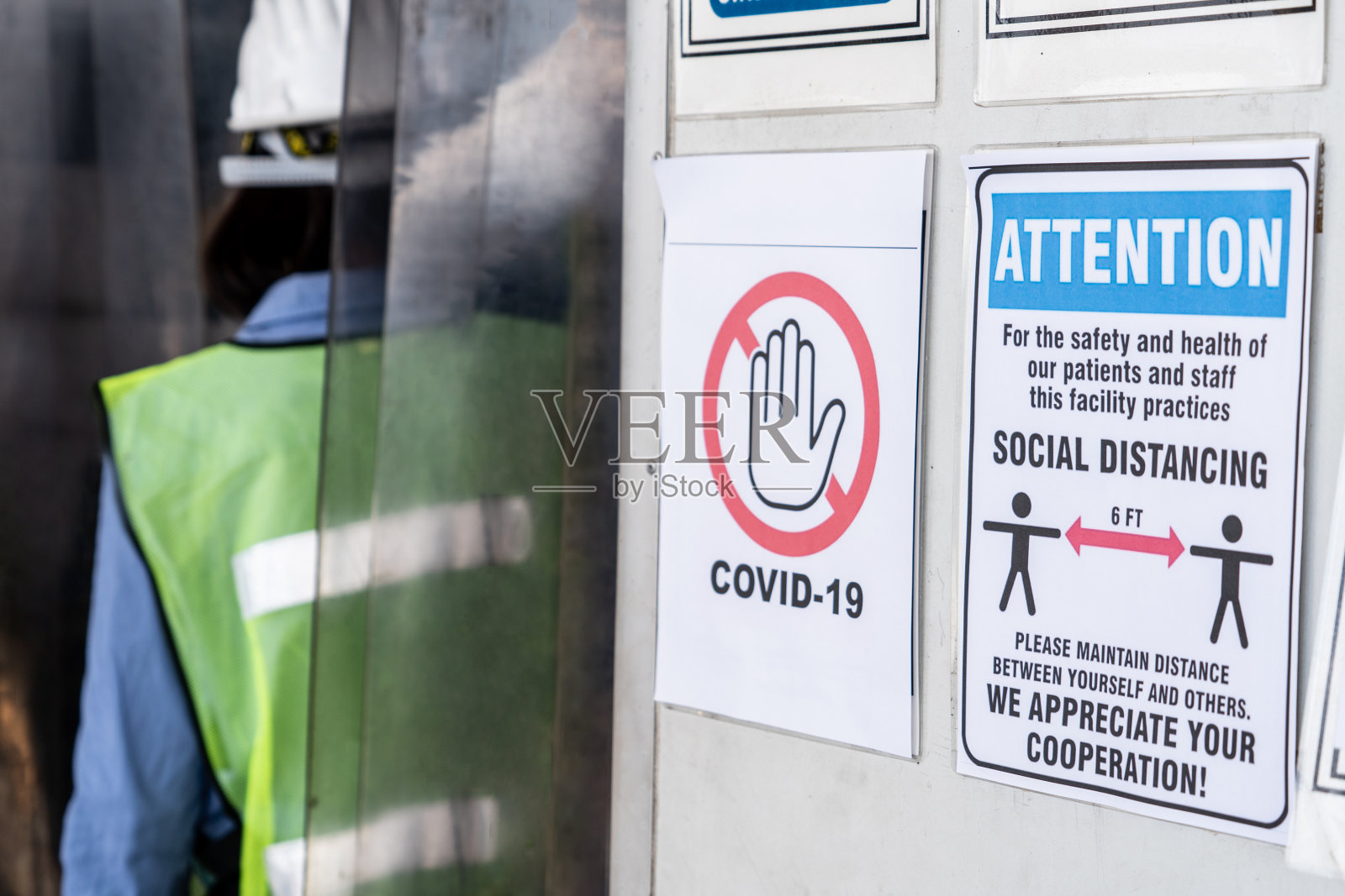 工厂里的警示标志提醒产业工人预防Covid-19照片摄影图片