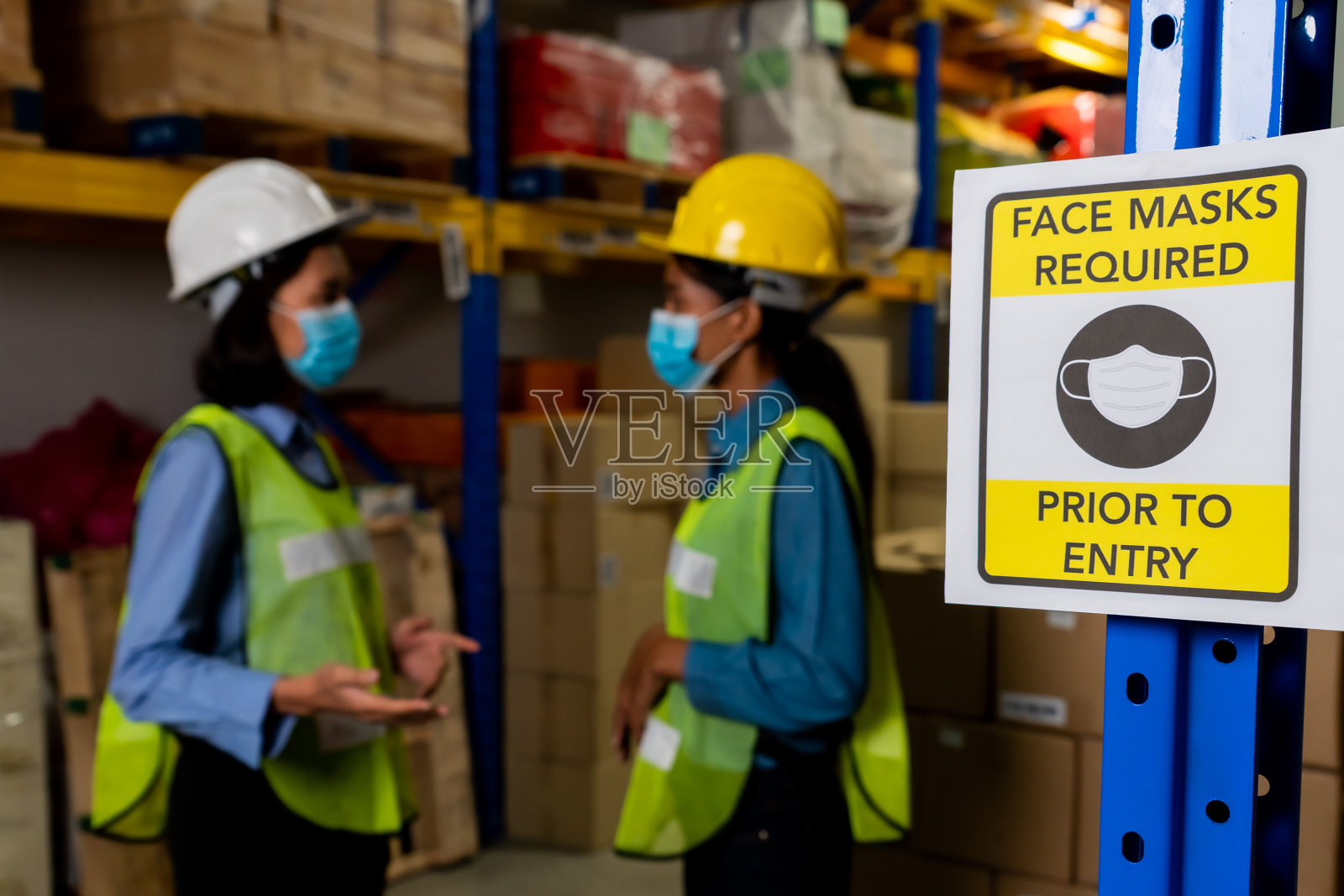 工厂里的警示标志提醒产业工人预防Covid-19照片摄影图片