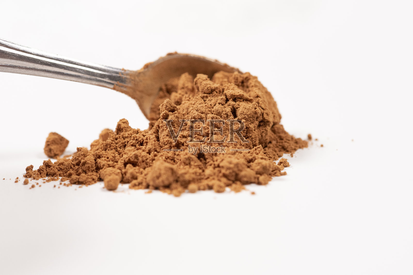 在白色背景上分离出可可粉。宏照片摄影图片