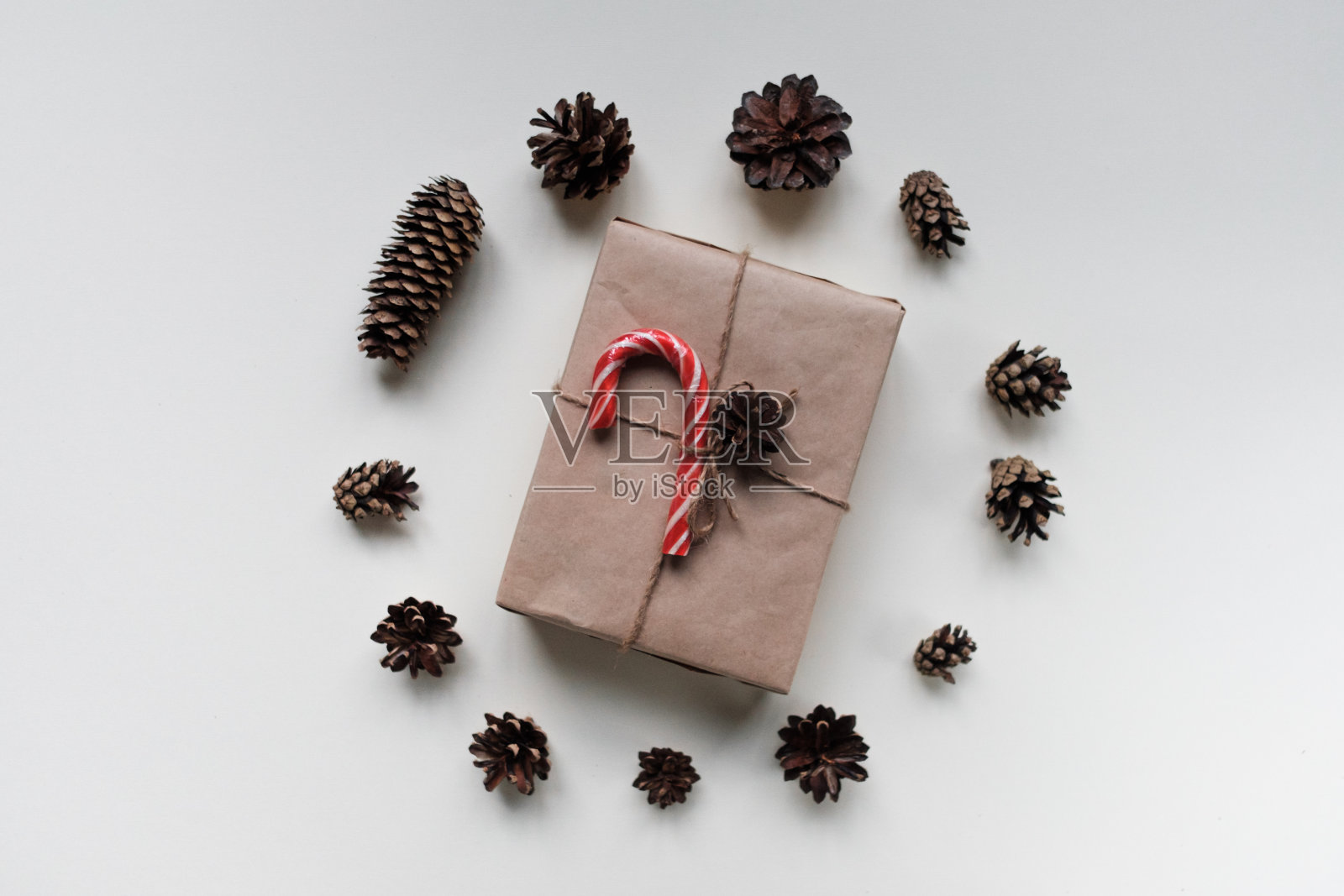 圣诞组成。圣诞礼物与圣诞糖果手杖，松果在白色的背景。俯视图，平放，复制空间。圣诞松果的组成照片摄影图片