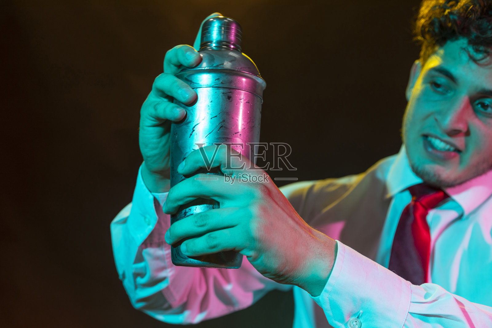 酒保准备酒精饮料与鸡尾酒调酒器在酒吧与一些酒杯利口酒。照片摄影图片