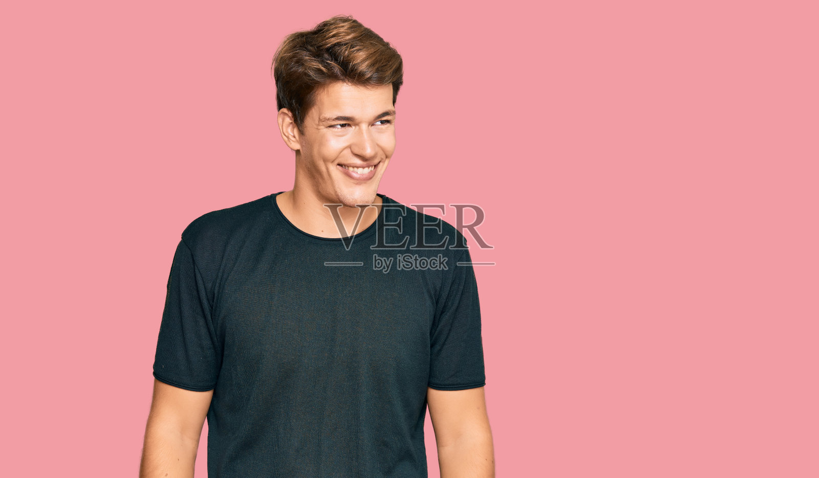 英俊的白人男子穿着休闲装，看向一边，脸上带着微笑，表情自然。自信的笑。照片摄影图片