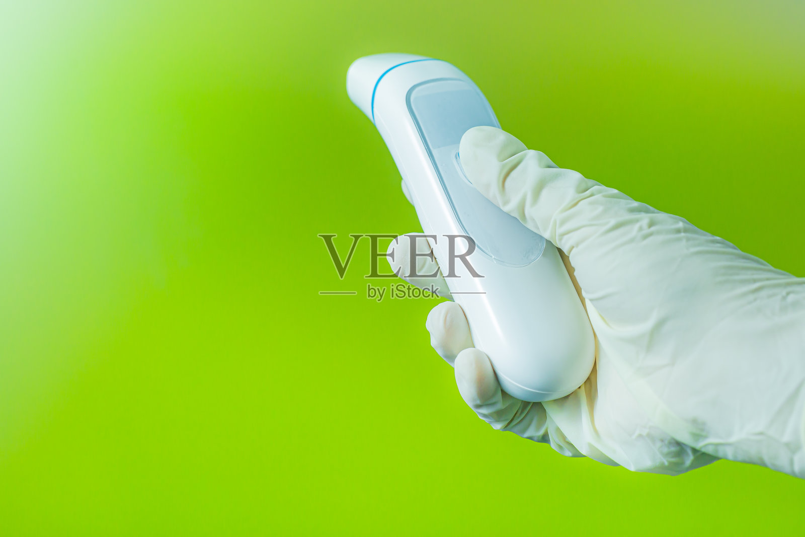 戴着手术手套的人手在绿色背景上检查体温照片摄影图片
