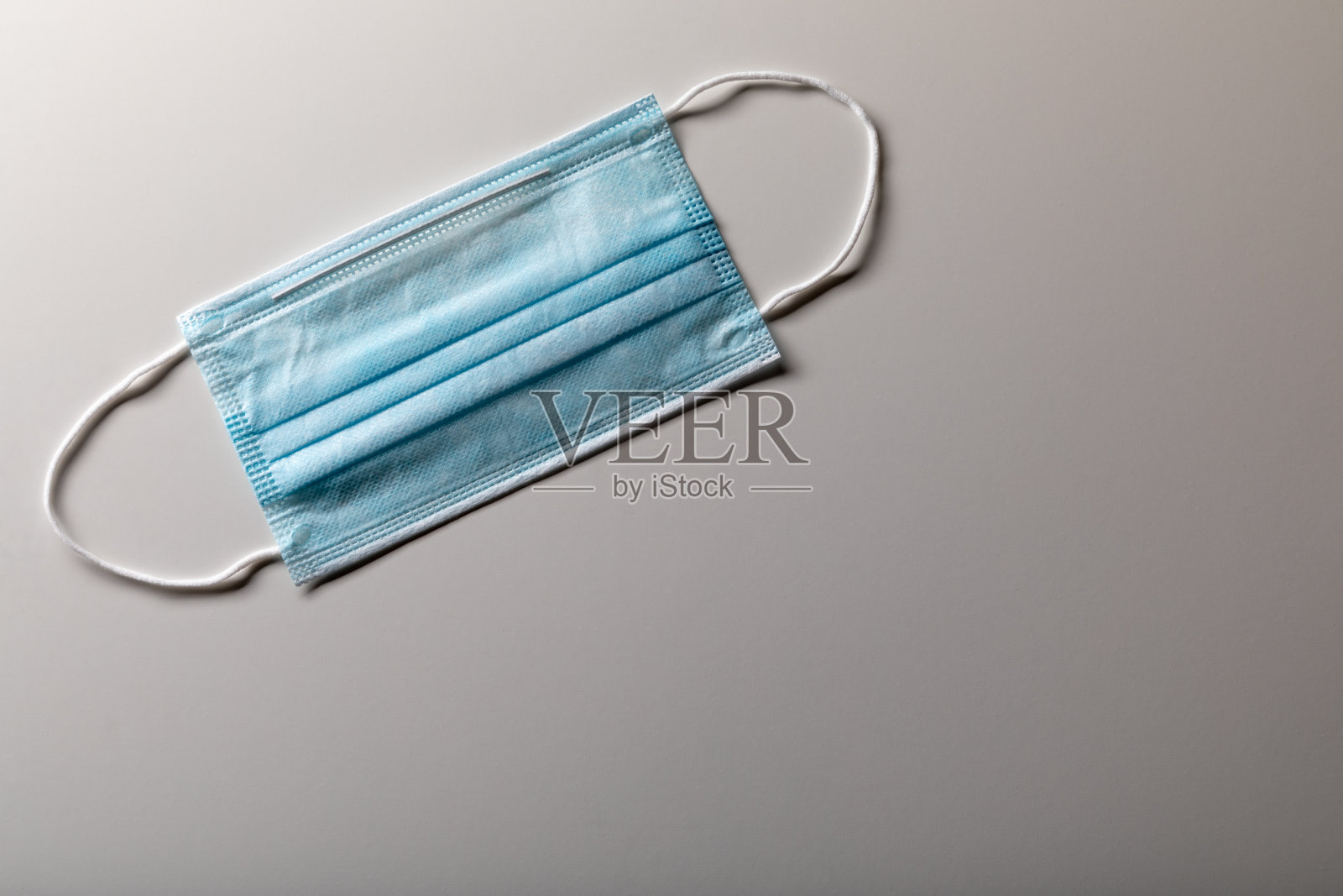 单一医用口罩放置在渐变表面照片摄影图片