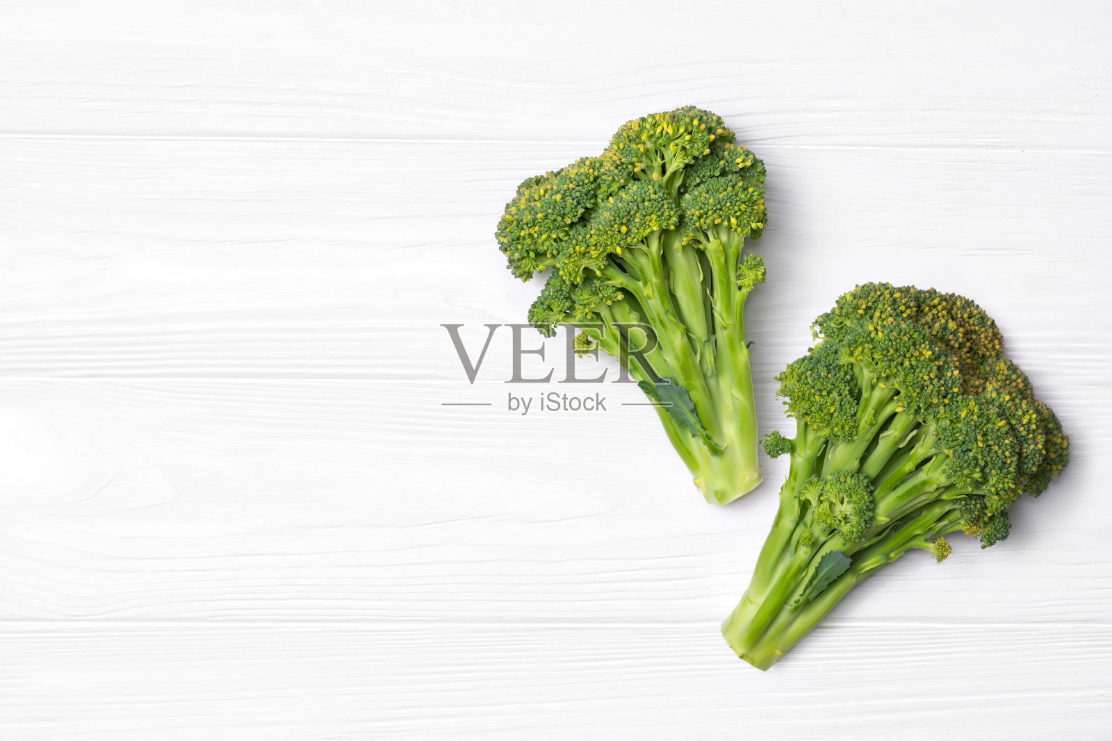 白木背景上的新鲜西兰花。照片摄影图片