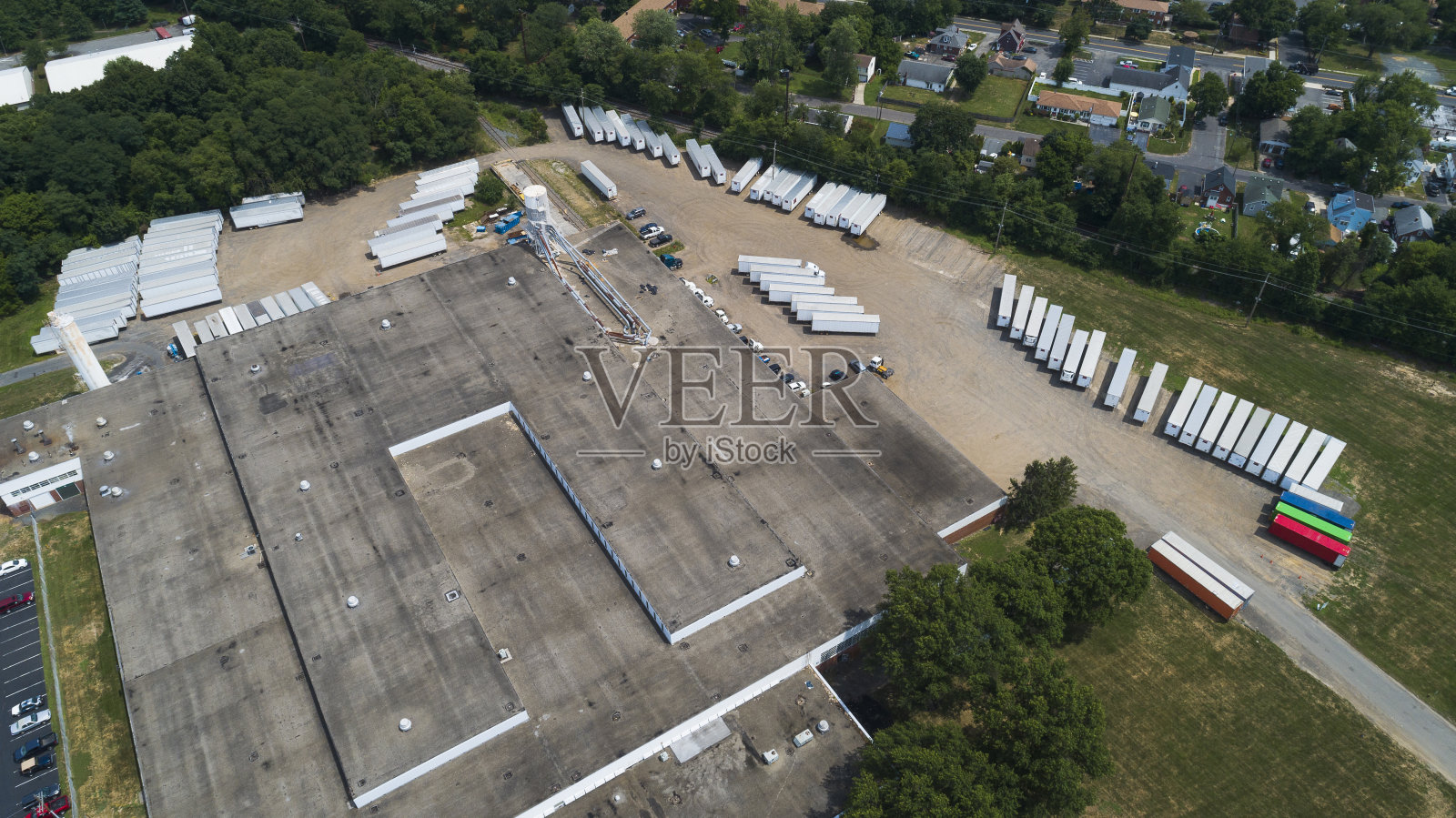 被停着的集装箱卡车包围的仓库建筑鸟瞰图。鸟瞰的视角。照片摄影图片