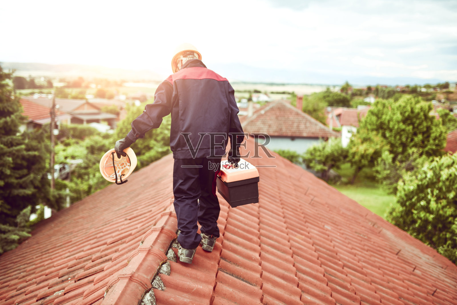 工人在屋顶上搬运工具箱照片摄影图片