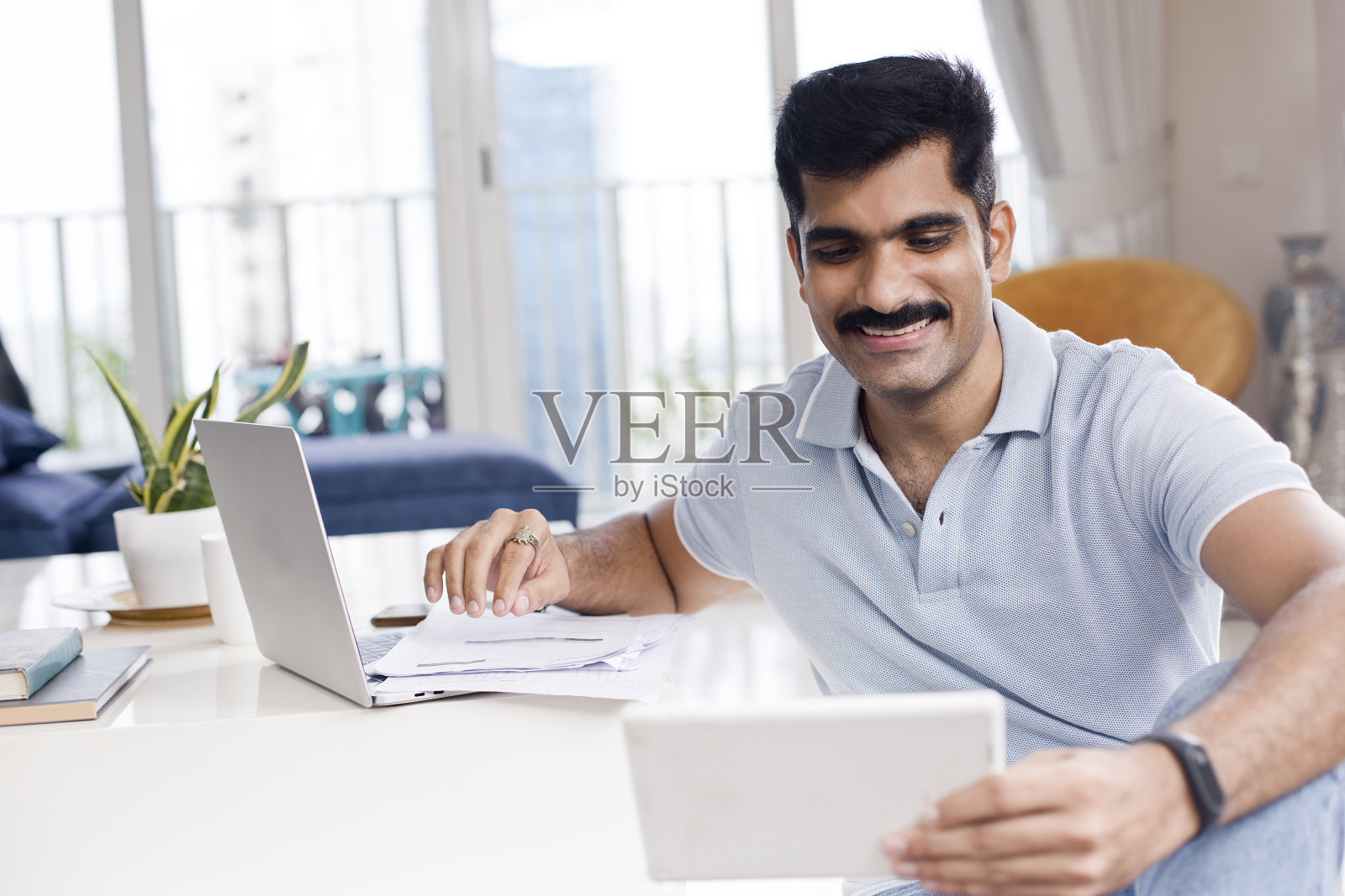 男人在家里用数字平板电脑和笔记本电脑工作照片摄影图片