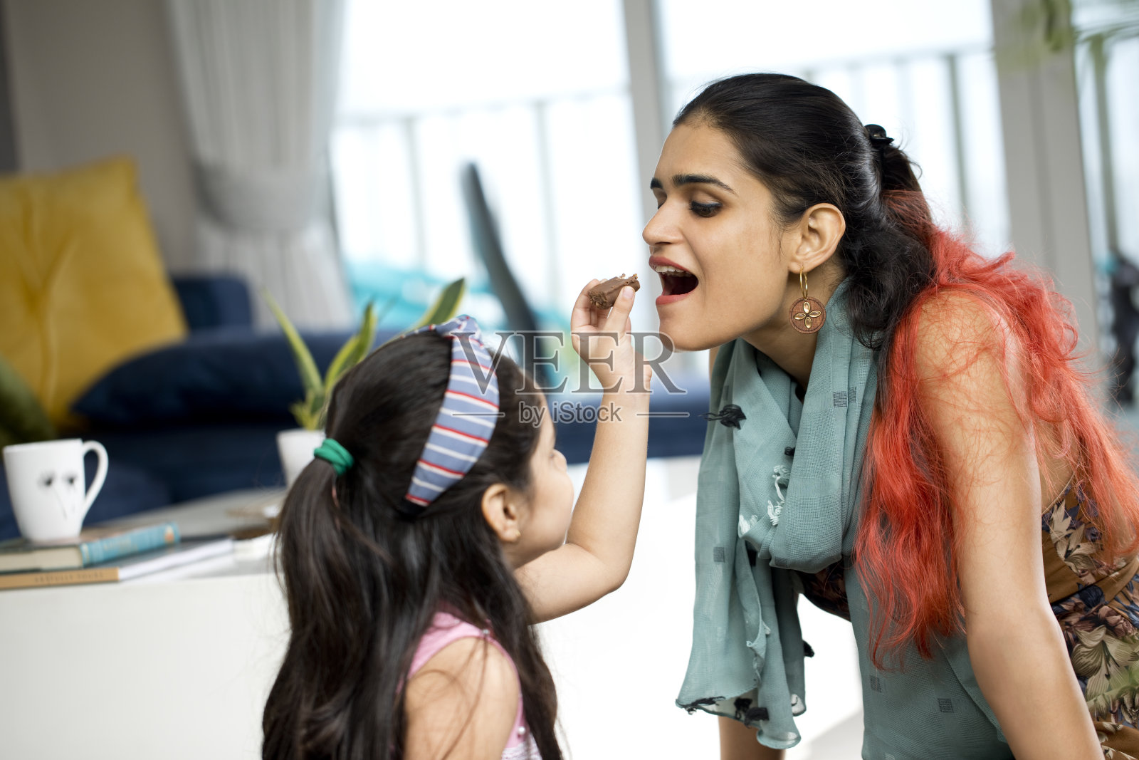 好玩的母亲和女儿在家里互相玩照片摄影图片