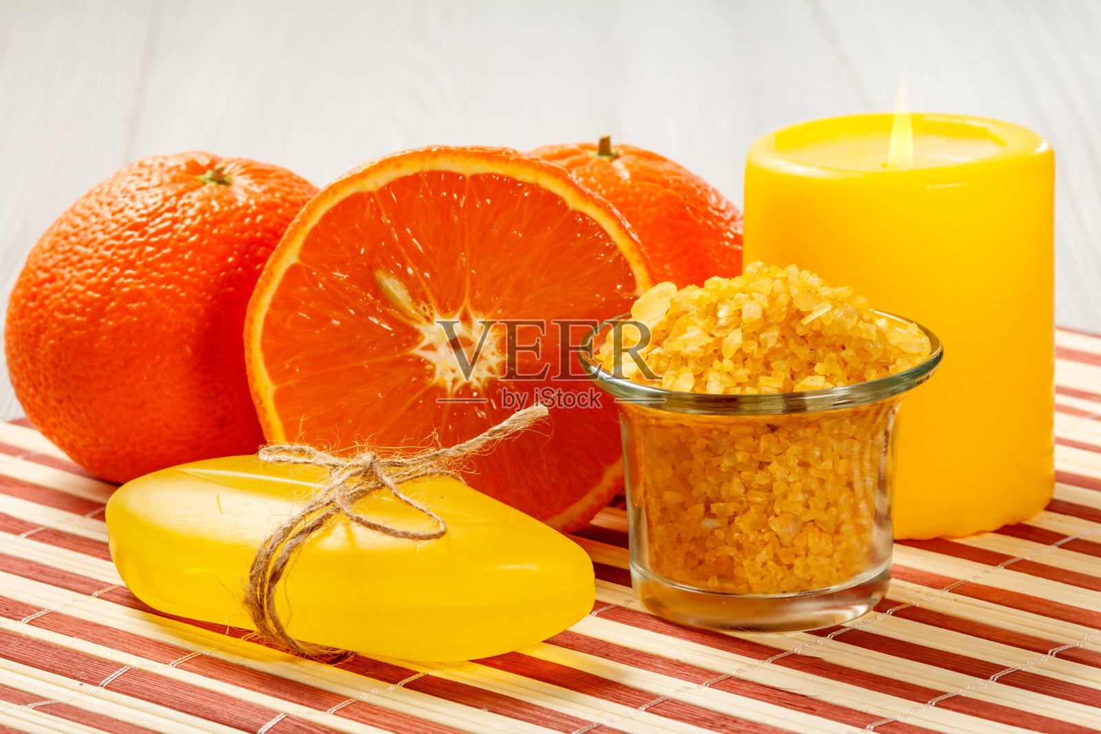用橘子，肥皂，海盐和蜡烛在木制餐巾上的水疗产品照片摄影图片
