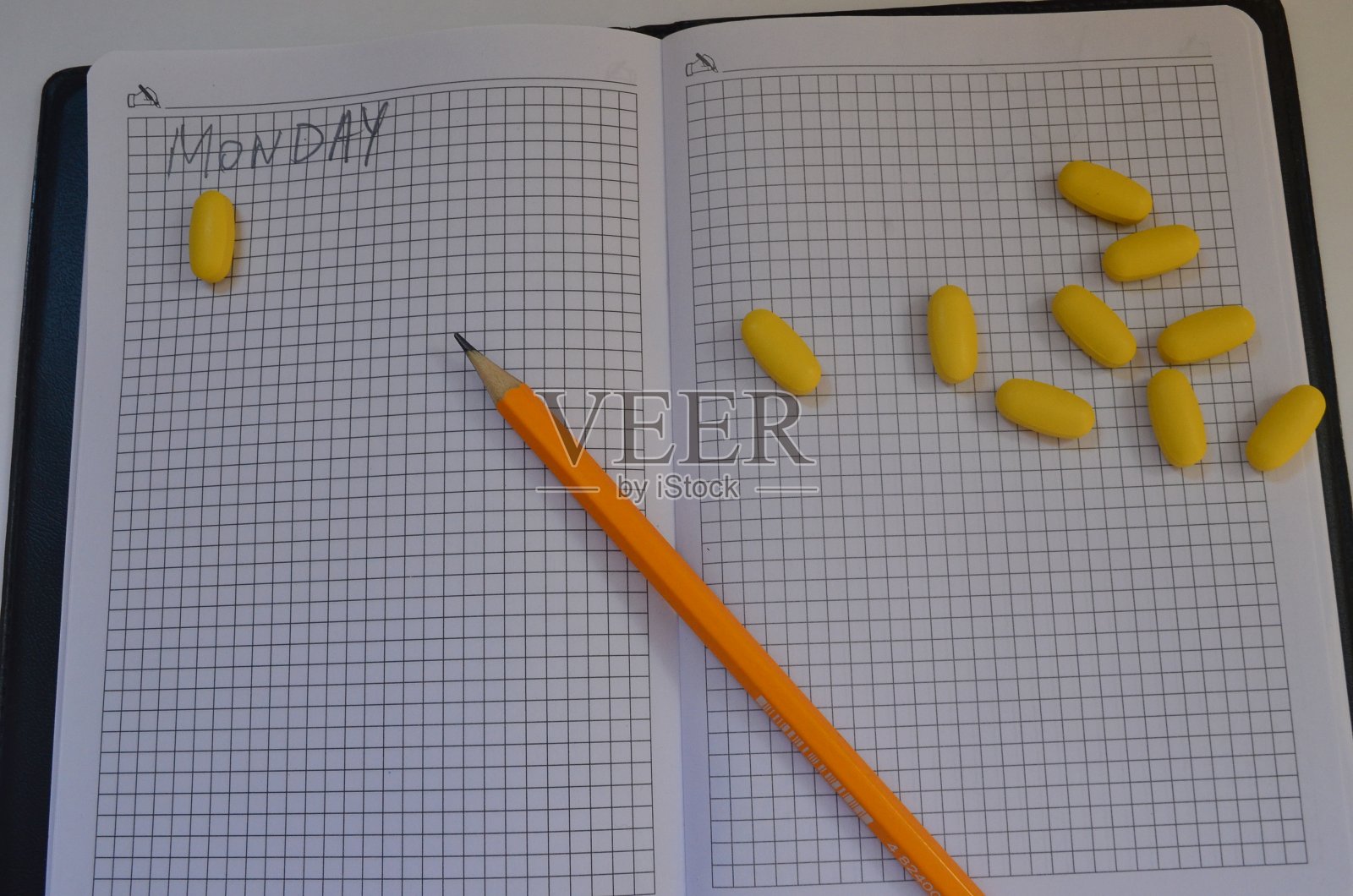 时间表上的黄色药片。治疗。药片,胶囊照片摄影图片