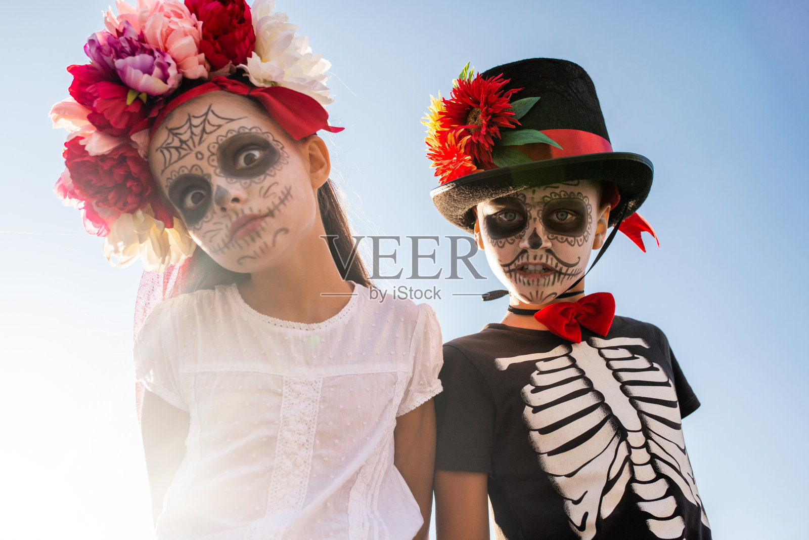 阴郁可怕的万圣节男孩和女孩画着脸看着你照片摄影图片