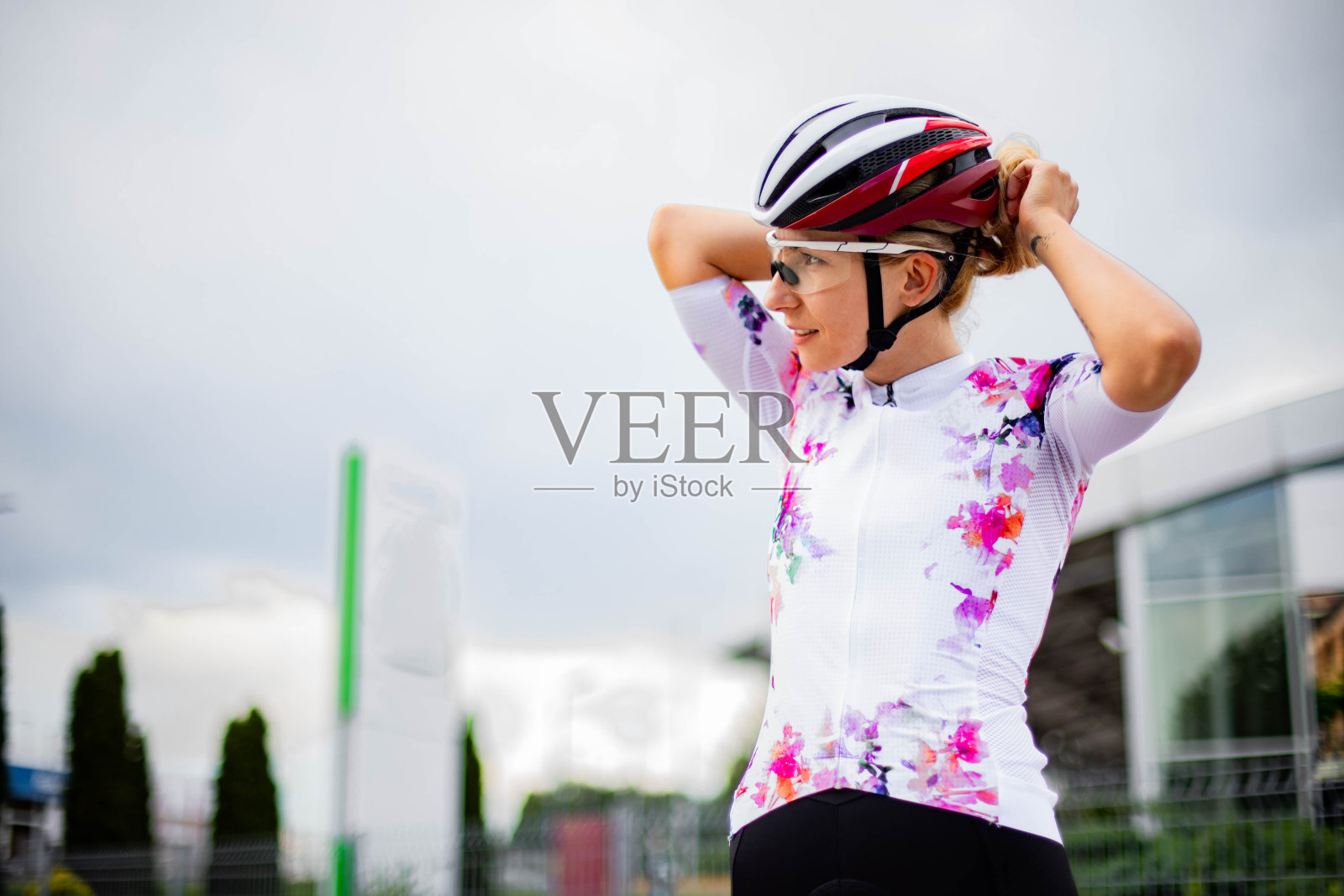 女自行车手正在设置她的头盔照片摄影图片