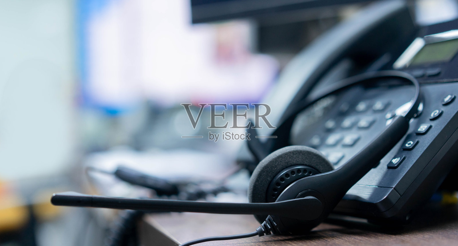在监控室的办公桌上采用呼叫中心的近距离耳机和VOIP通信技术，实现网络运行的工作理念照片摄影图片