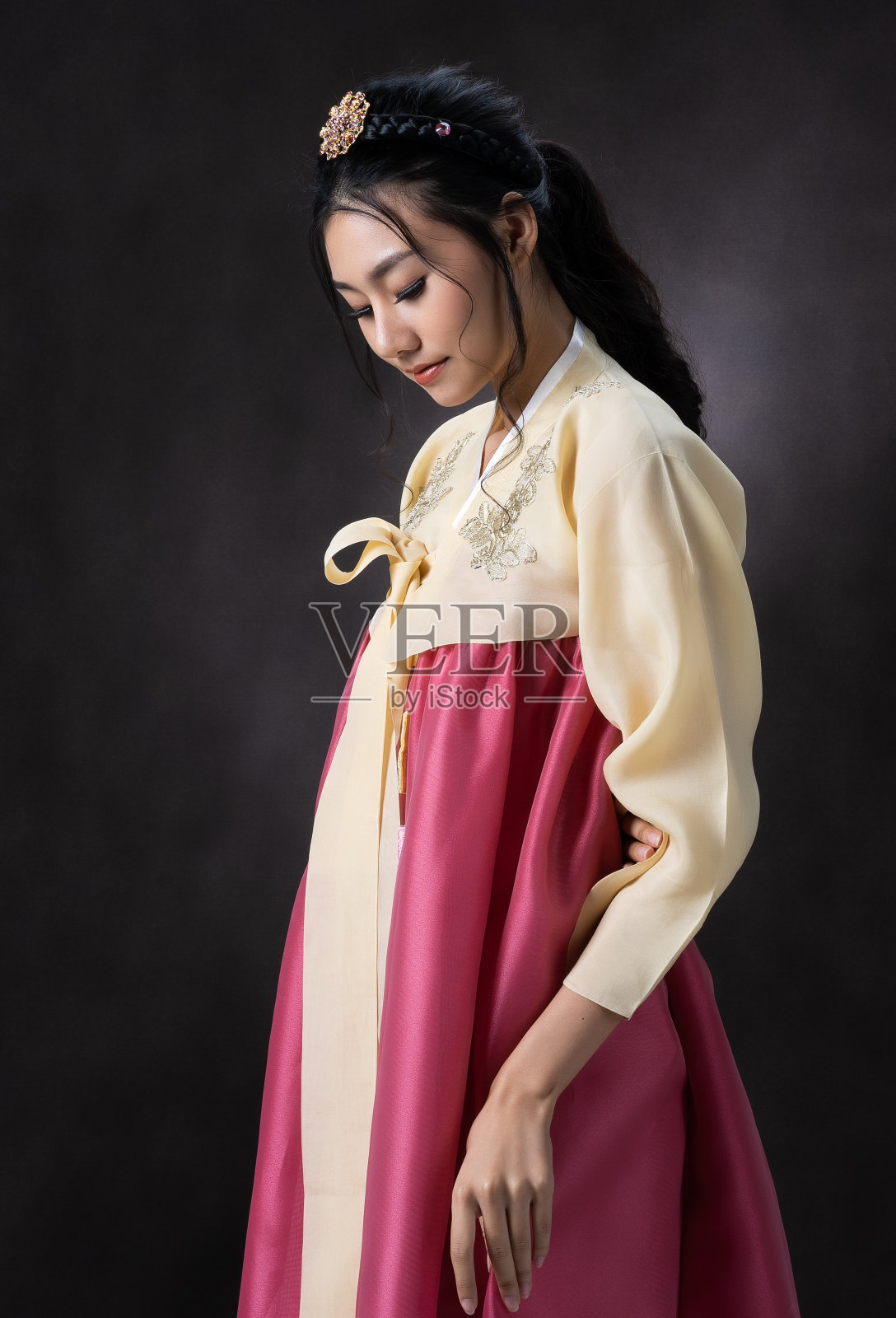 肖像年轻的亚洲妇女在韩国传统服装，韩服在工作室拍摄，黑色的背景。照片摄影图片