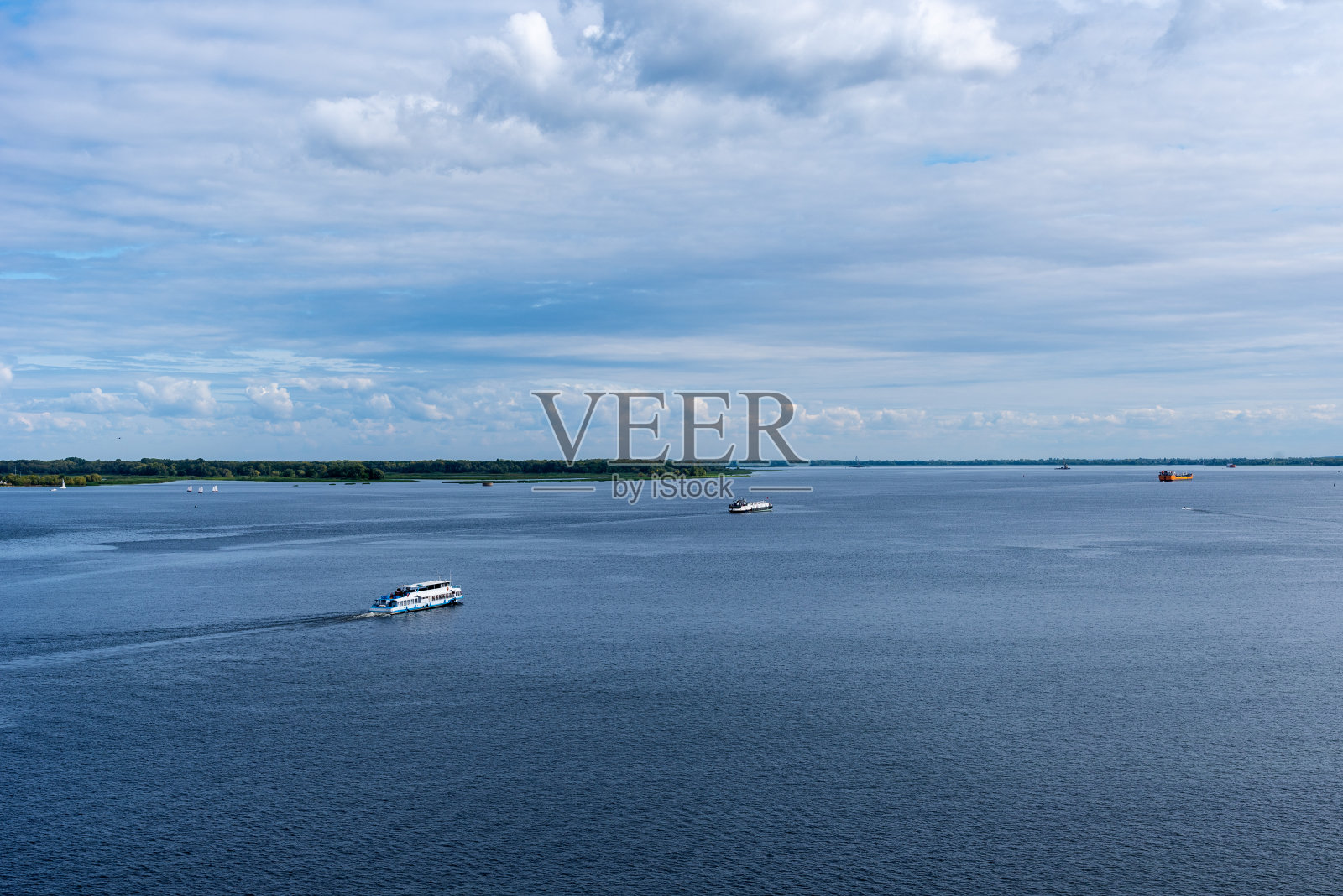 在一个阳光明媚的日子，一艘油船沿着海岸航行照片摄影图片