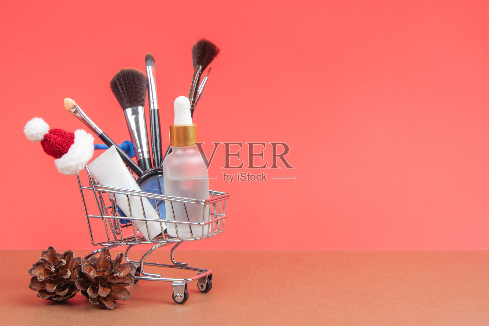 皮肤护理化妆品和化妆刷在一个杂货推车上的圣诞背景。皮肤护理的概念。照片摄影图片
