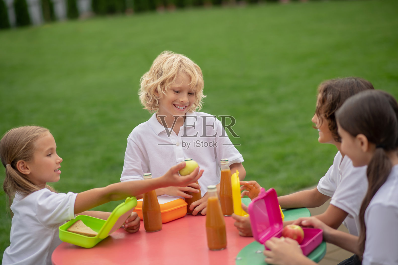 朋友们坐在桌边吃午饭照片摄影图片