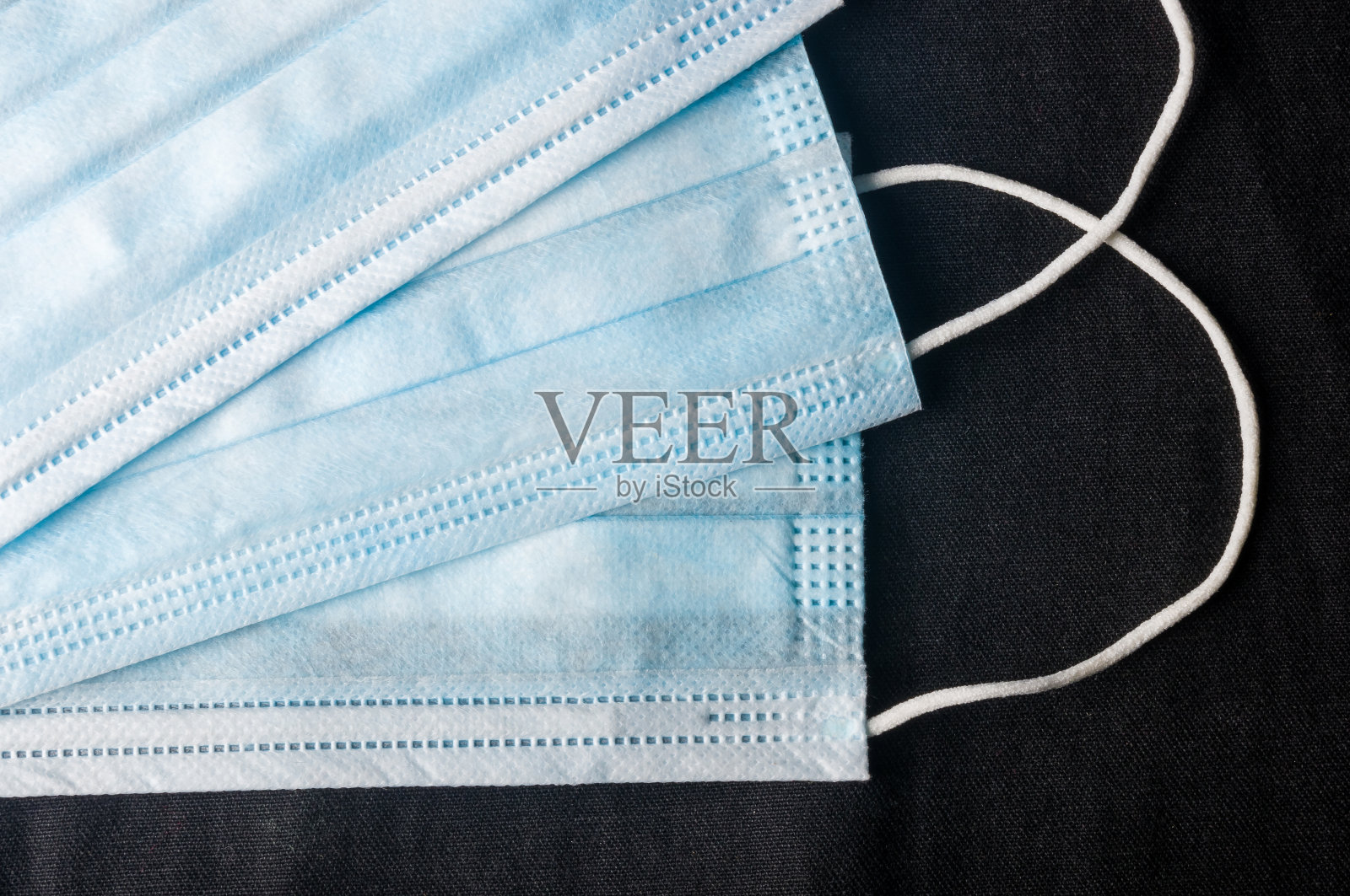 新型冠状病毒(COVID-19)大流行新闻的背景概念，用于预防冠状病毒的抗病毒医疗口罩。手术防护面具。医用呼吸包扎面部，拷贝空间刻字。照片摄影图片