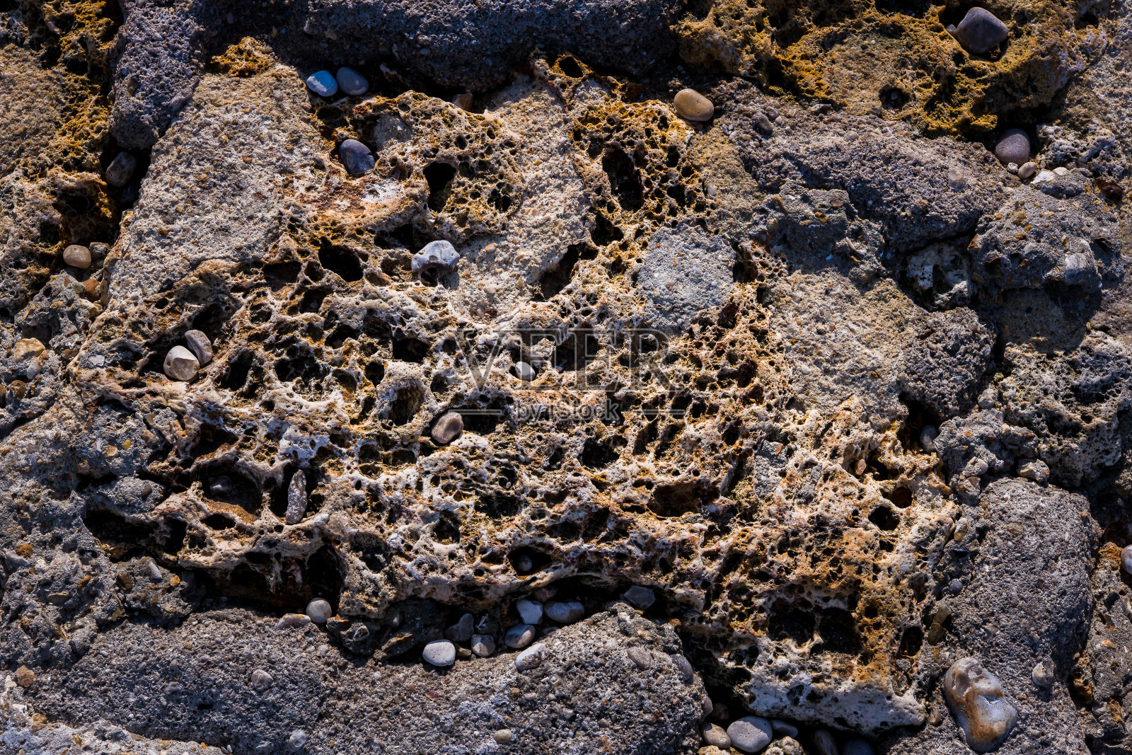 有洞和不规则形状的岩石、石头、多孔卵石照片摄影图片