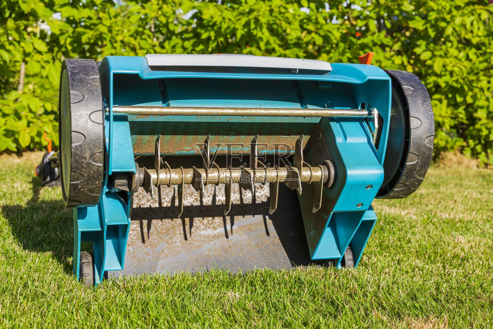 近距离观看电动草坪曝气机对绿草隔离。花园机器的概念。照片摄影图片