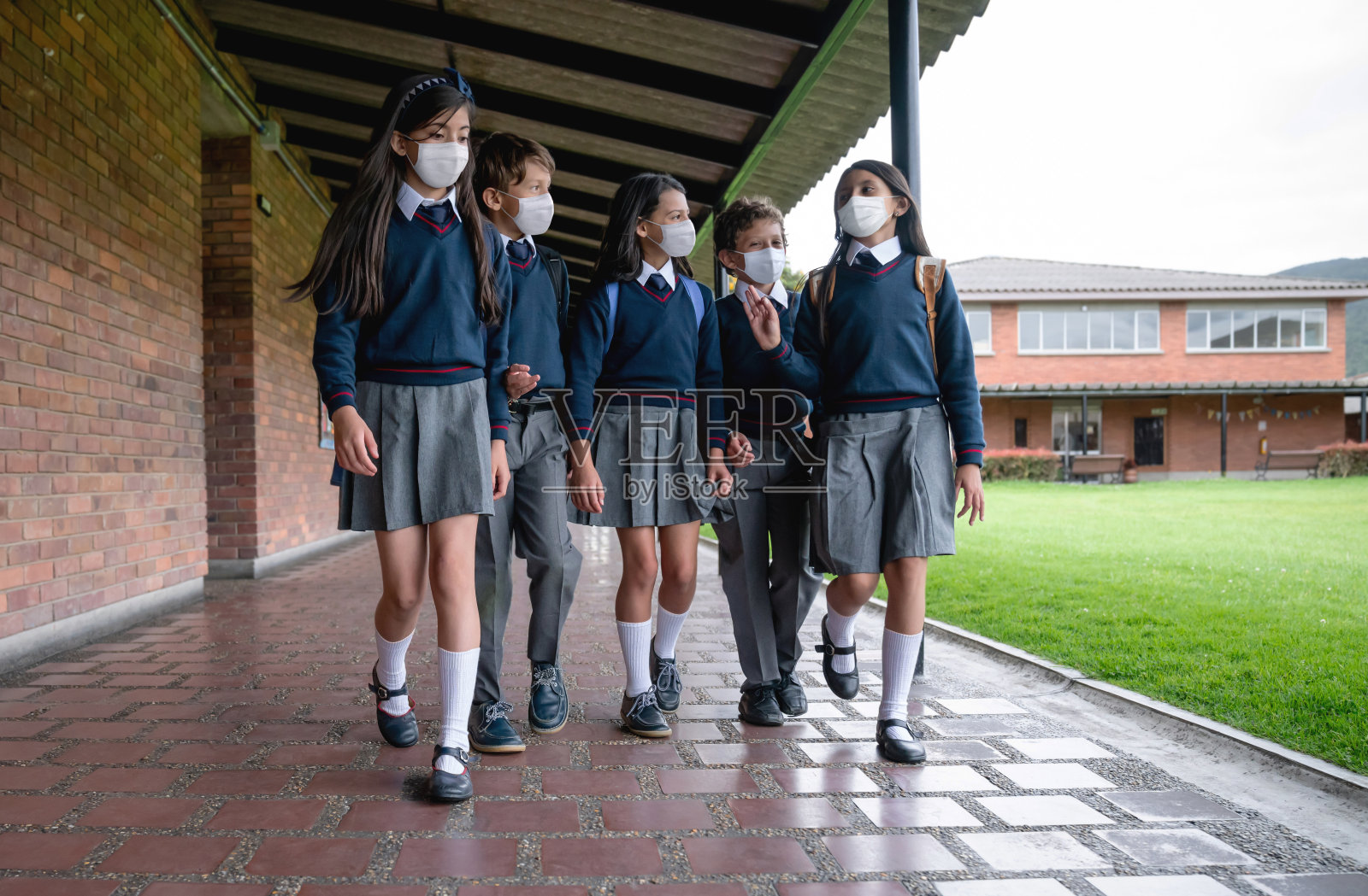 一群学生戴着口罩在学校讲话照片摄影图片