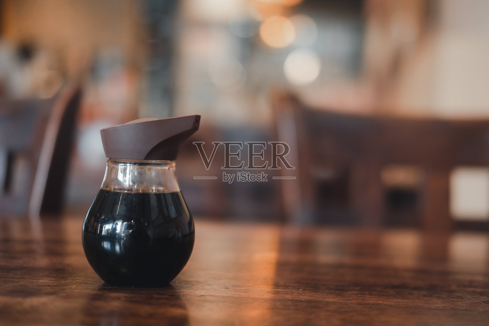 泰国一家日式餐厅的木桌上摆放着一瓶装寿司的烧鱼酱照片摄影图片