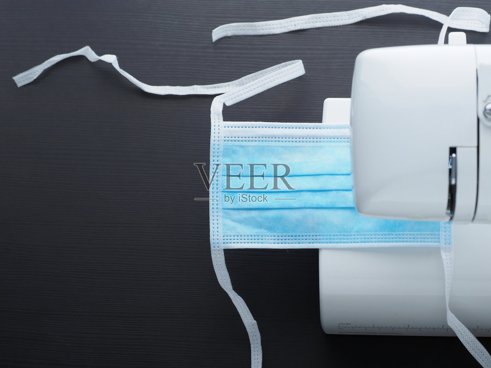 在缝纫机上缝制医用口罩。副本的空间。照片摄影图片