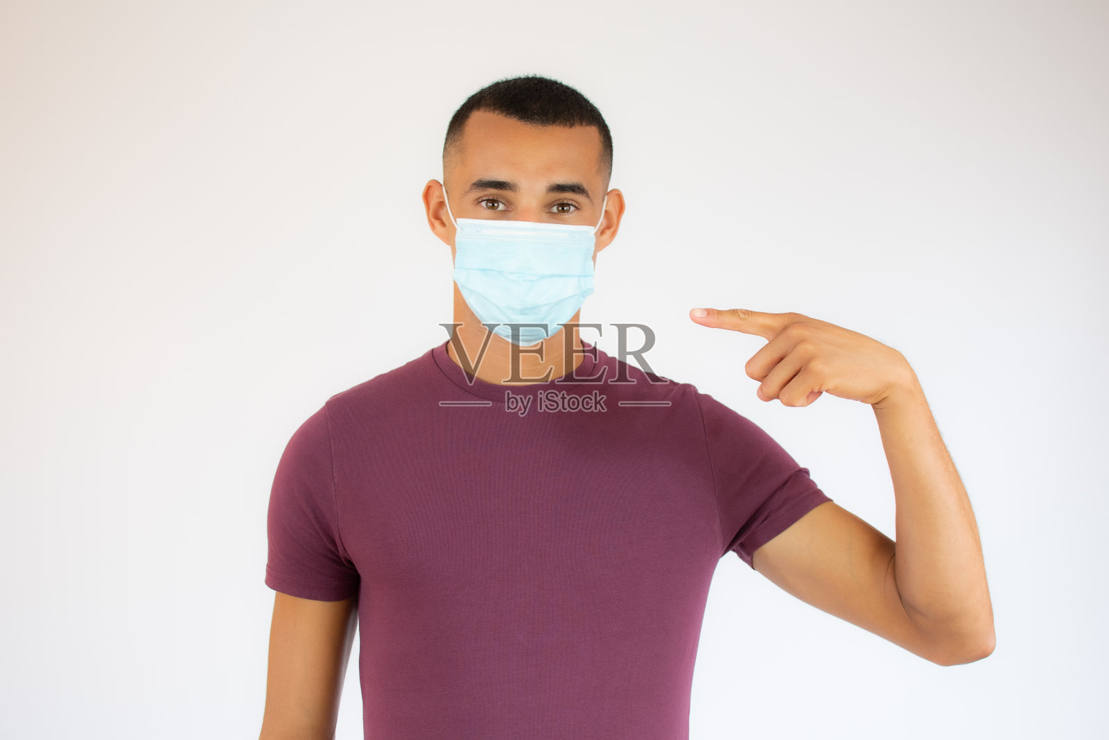 年轻男子戴着外科口罩，以防止病毒在白色背景照片摄影图片