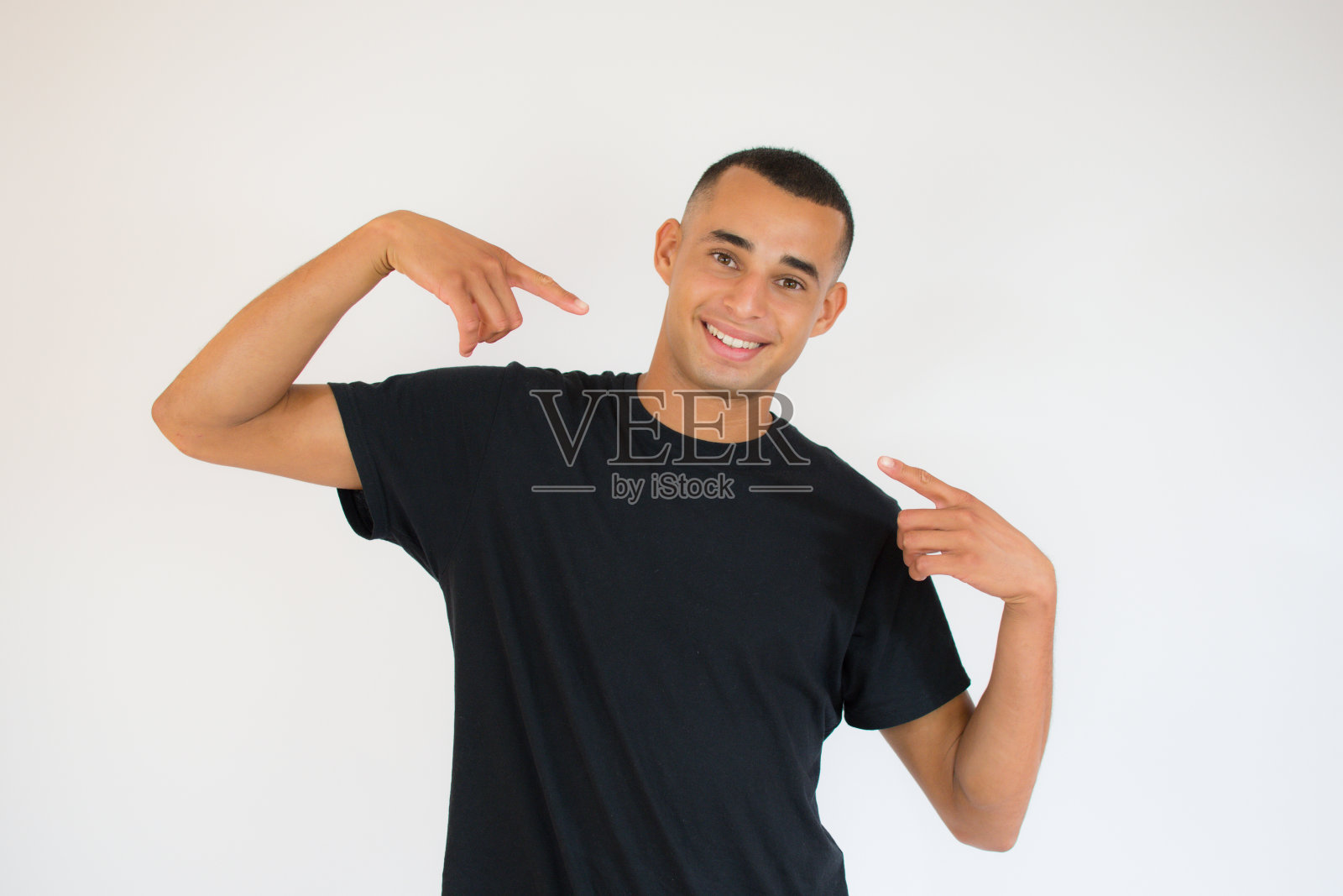 年轻英俊的男人在孤立的背景微笑自信的显示和指向手指，牙齿和嘴照片摄影图片