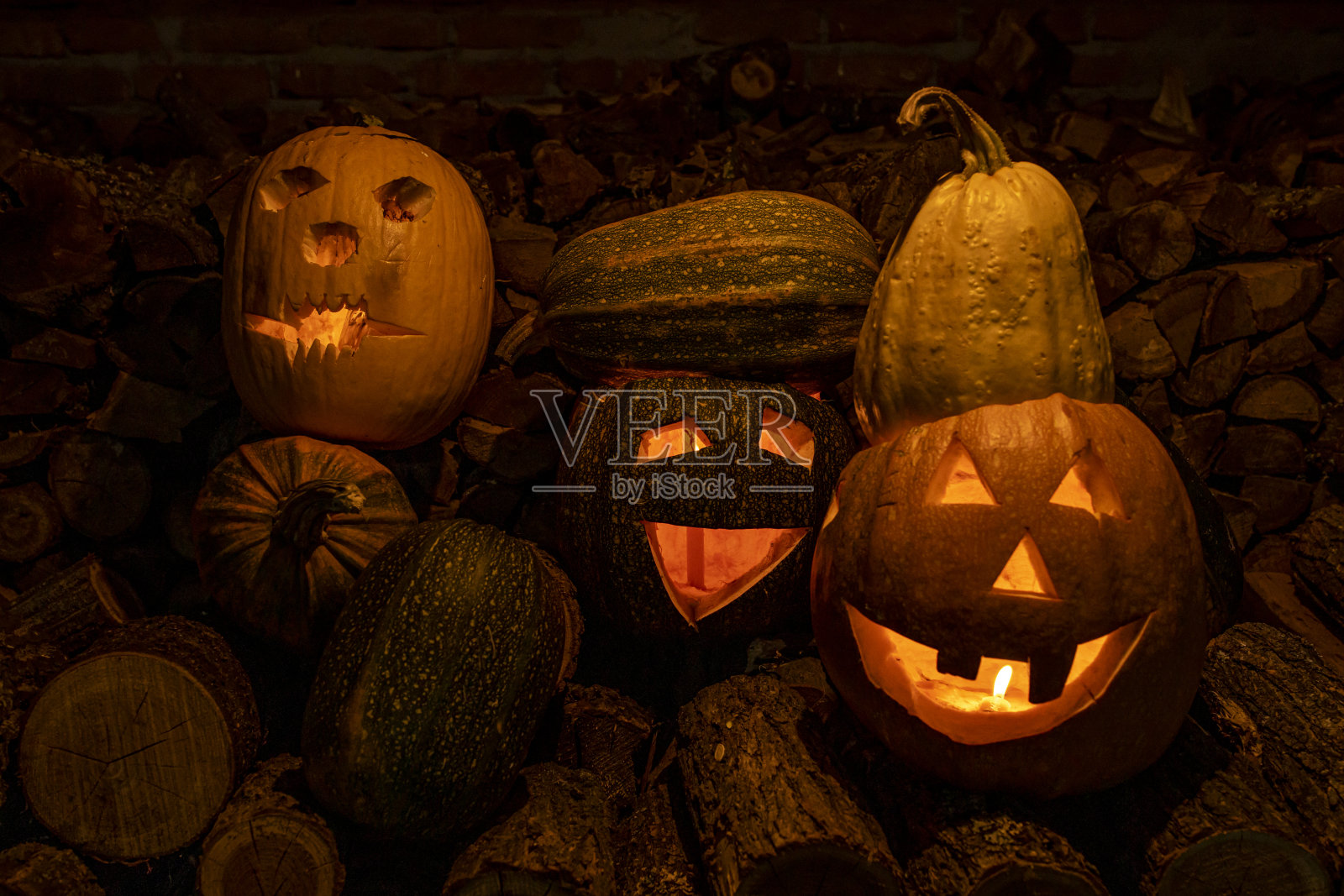 万圣节的南瓜放在一堆砍好的木头上照片摄影图片