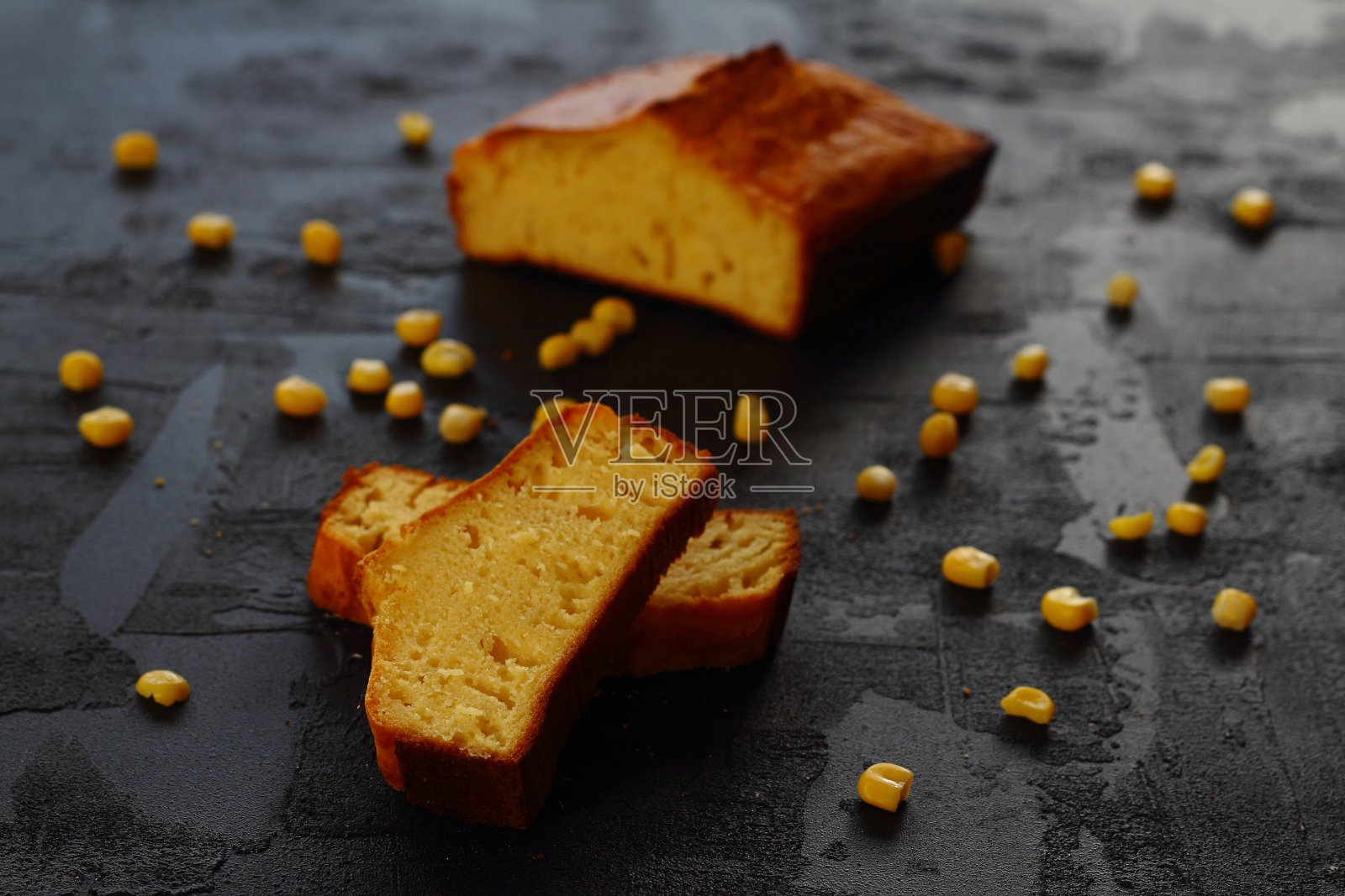 玉米面包和刀在黑色的背景。用新鲜的玉米。照片摄影图片