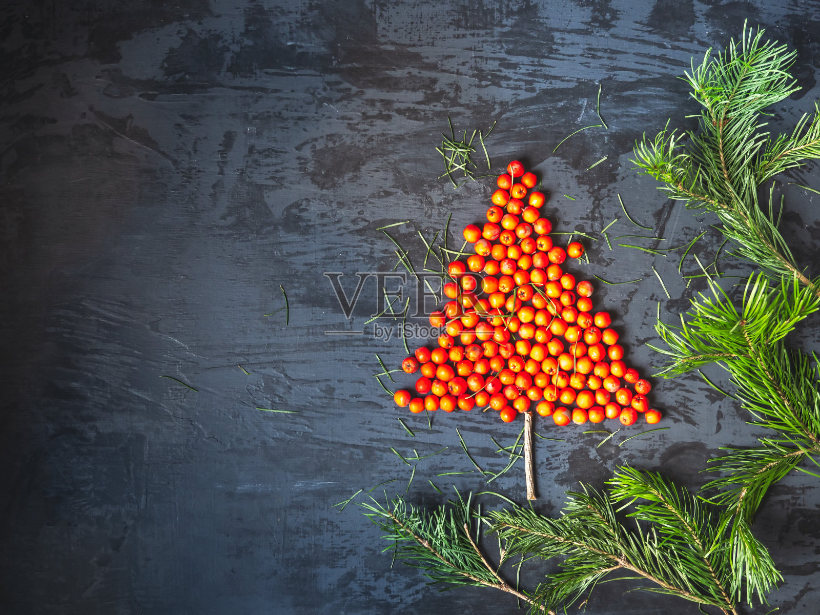 新年贺卡与杉树制成的花楸浆果和冷杉树枝在黑暗的背景照片摄影图片