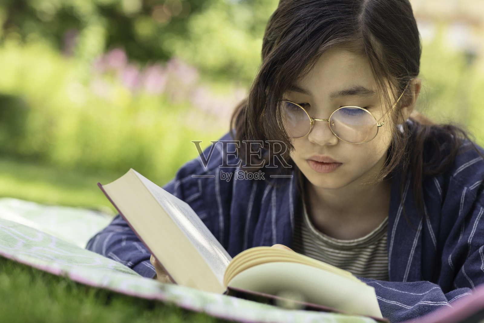 女孩在公园里看书照片摄影图片