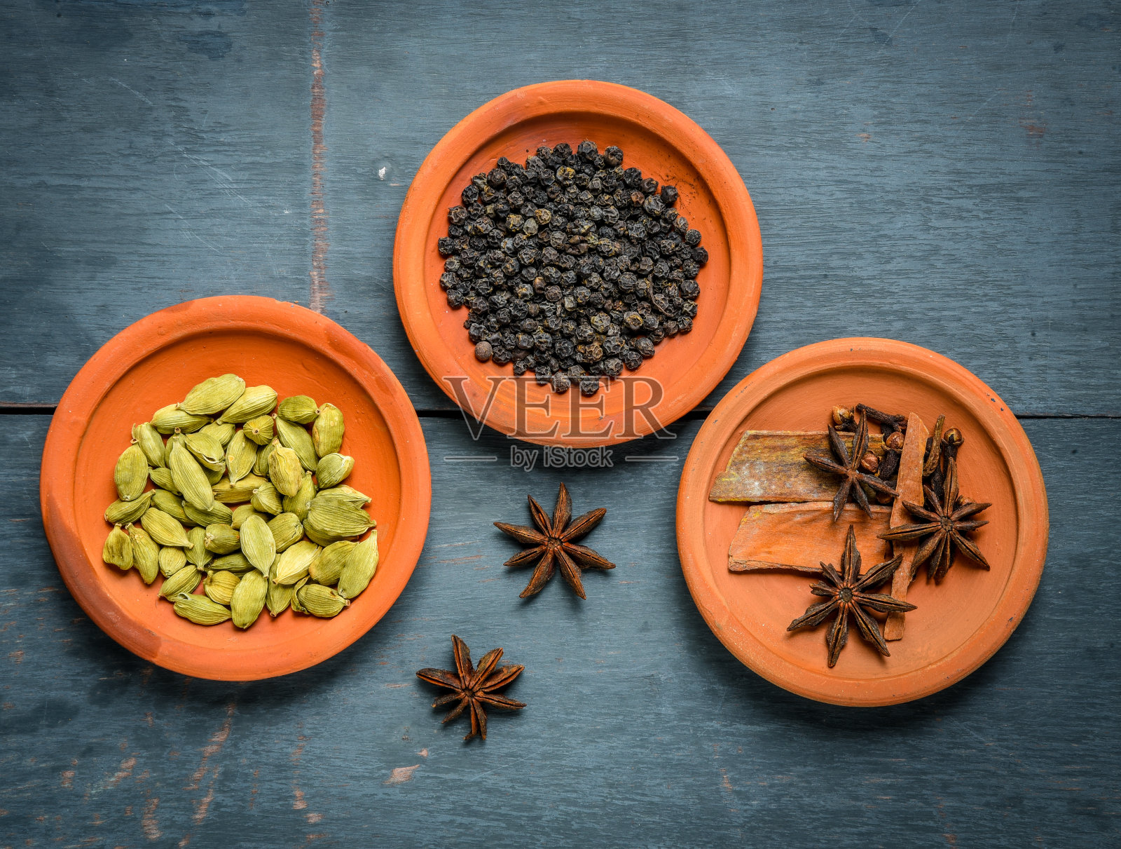 咖喱鸡或香料，辣红鸡腿片配香菜叶，安排在一个白色陶瓷碗与木制背景照片摄影图片