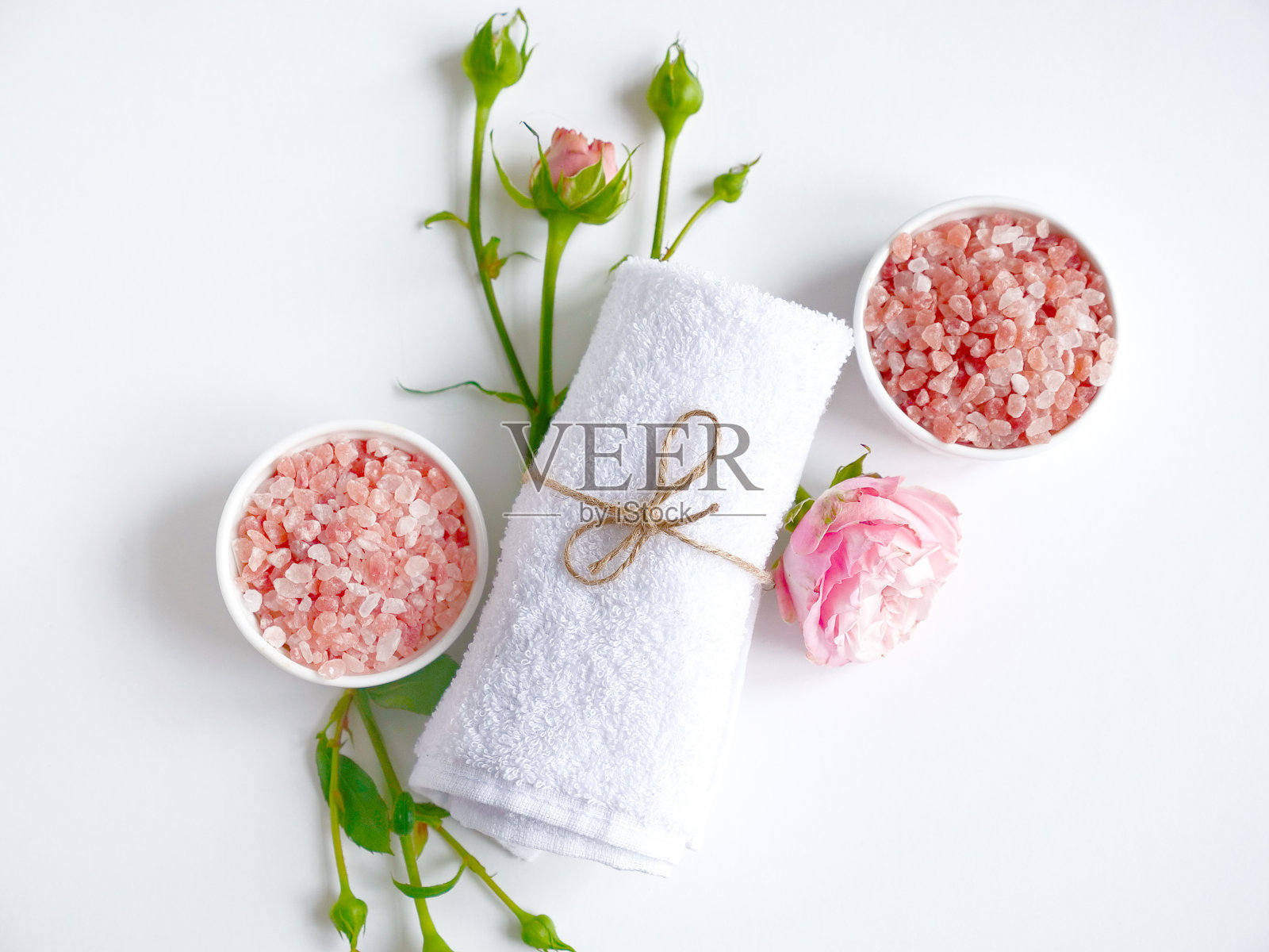 Spa flatlay组成。海盐缸，毛巾，白底花。前视图。日常护理理念，放松休息，沐浴程序照片摄影图片