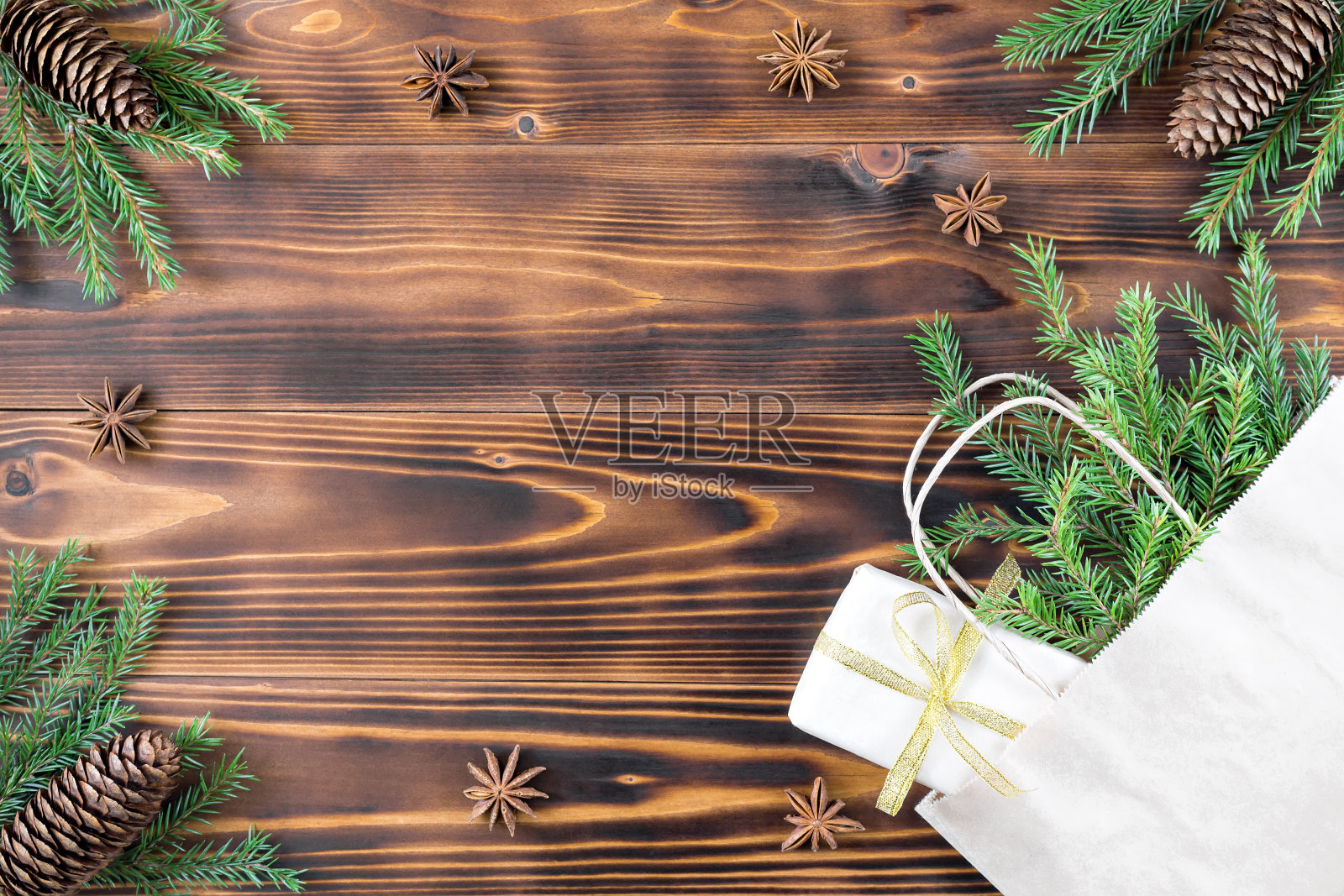 圣诞盒子与礼物在一个纸袋在木背景云杉枝，茴香和球果照片摄影图片
