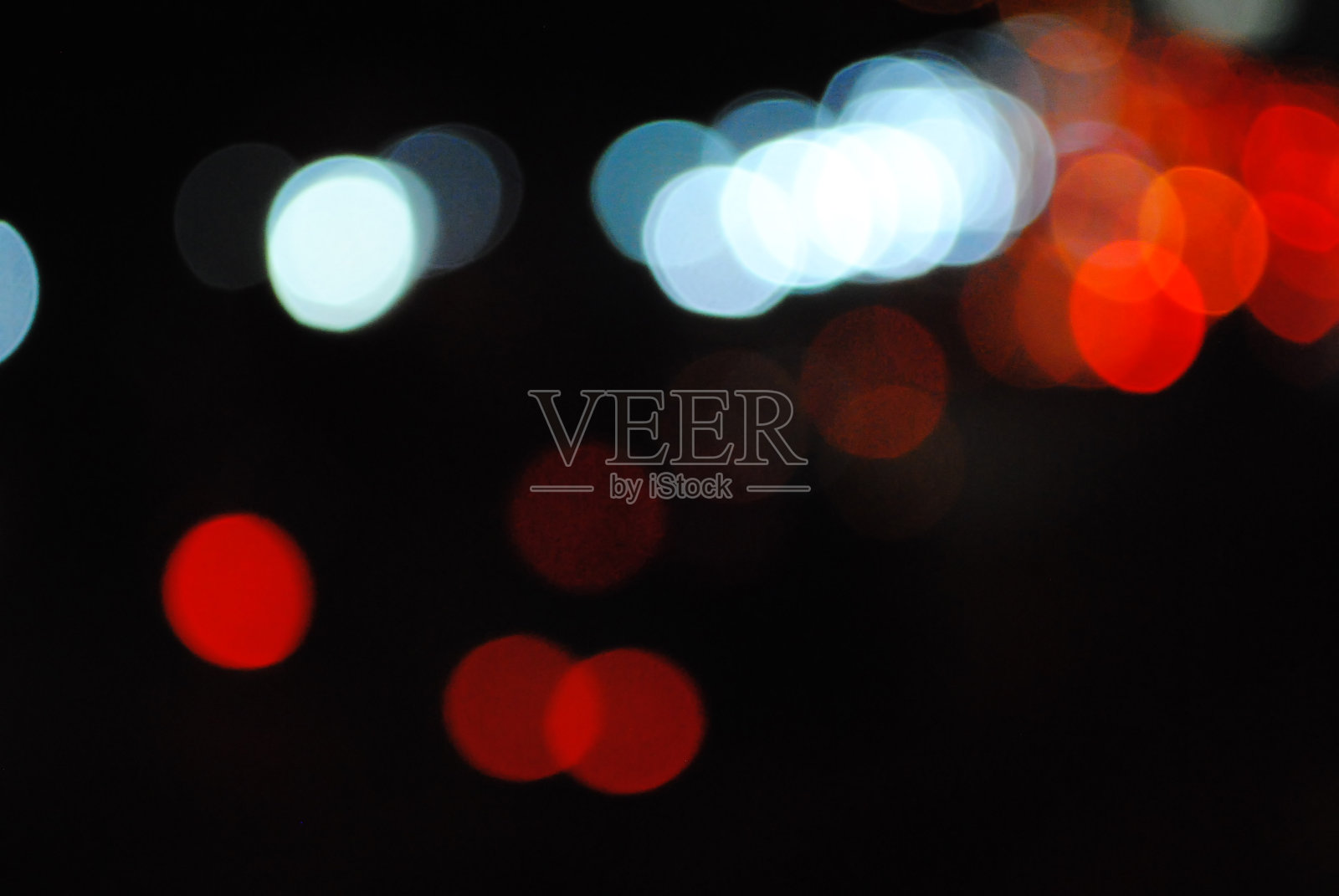 Bokeh交通灯在一个大城市的街道上。抽象背景的模糊温暖灯光与冷蓝色和紫色背景与散景效果照片摄影图片