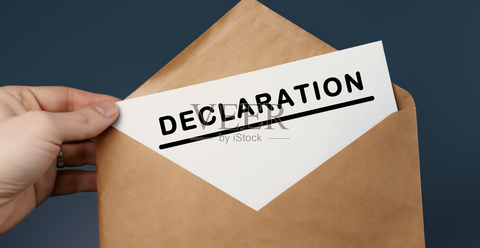 抱着印有蓝色背景文字宣言的手工信封的男子的裁剪视图照片摄影图片