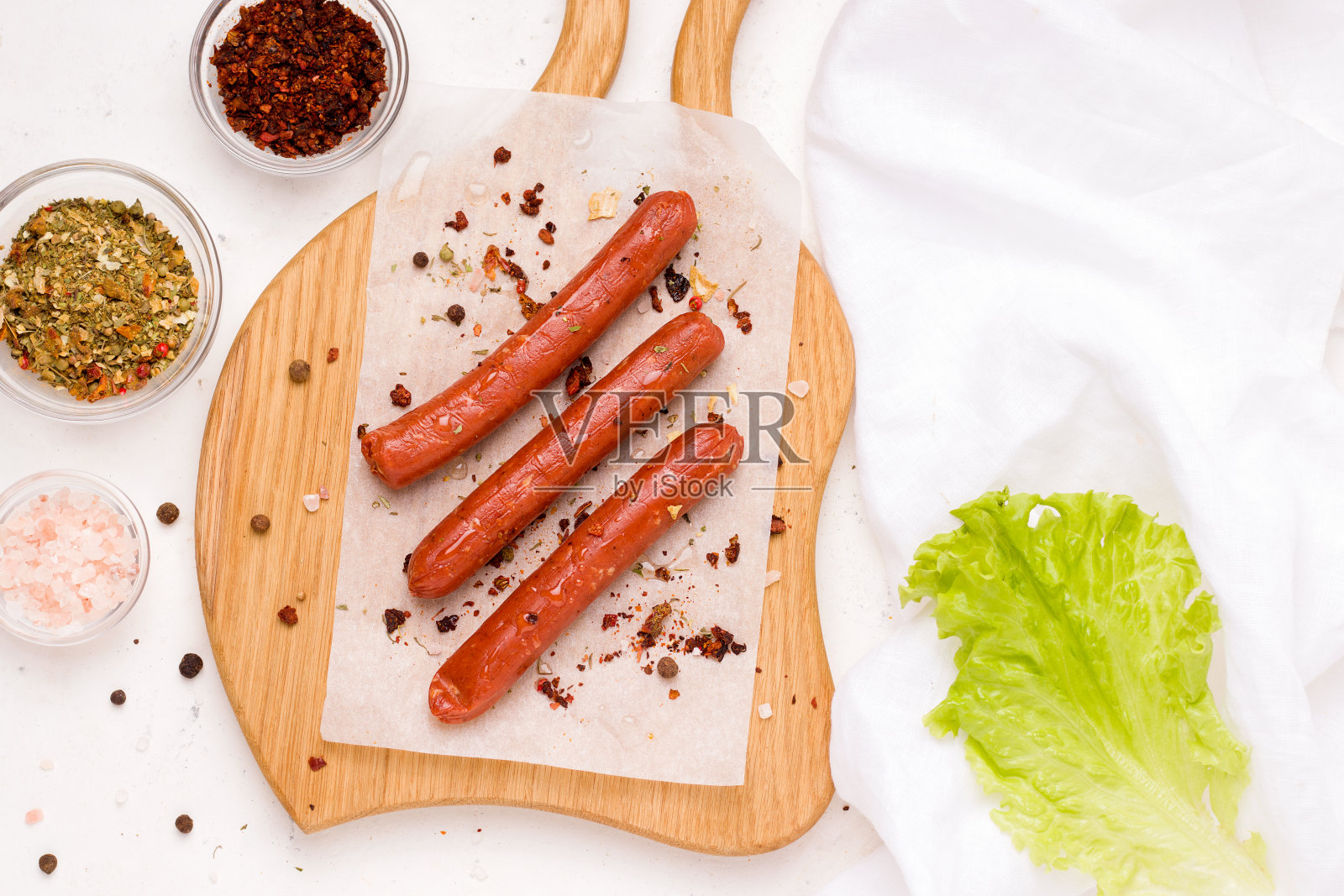 素菜香肠配上香料和西红柿，放在白盘子里。副本的空间。照片摄影图片