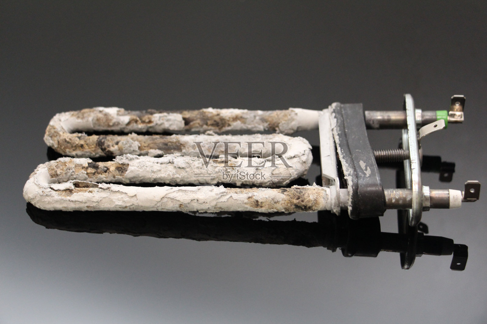 电加热器和腐蚀性热水器加热元件带有水垢和沉积物。照片摄影图片