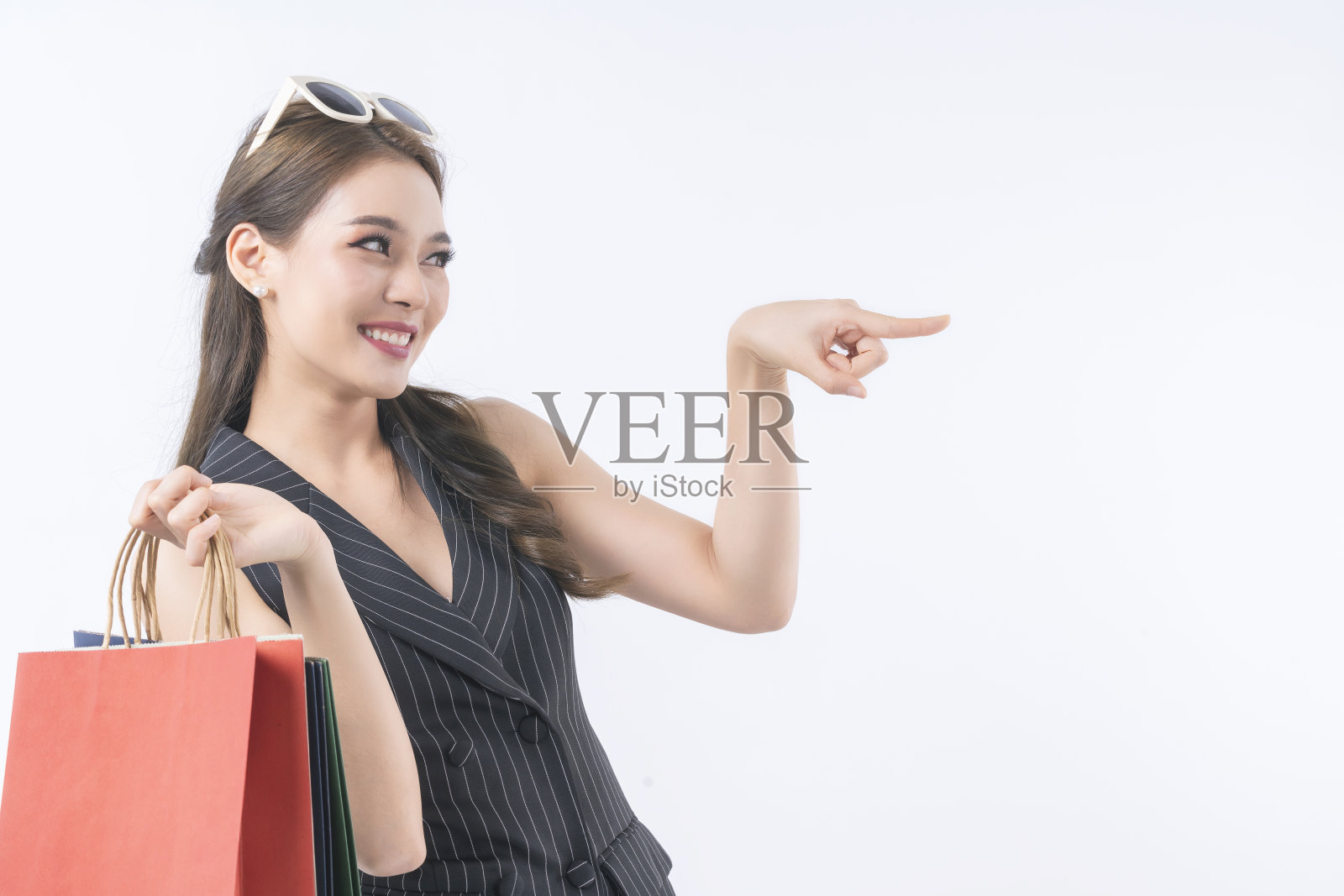 迷人的亚洲女性女人喜欢购物手持彩色购物袋微笑与开朗和自信孤立的白色背景照片摄影图片