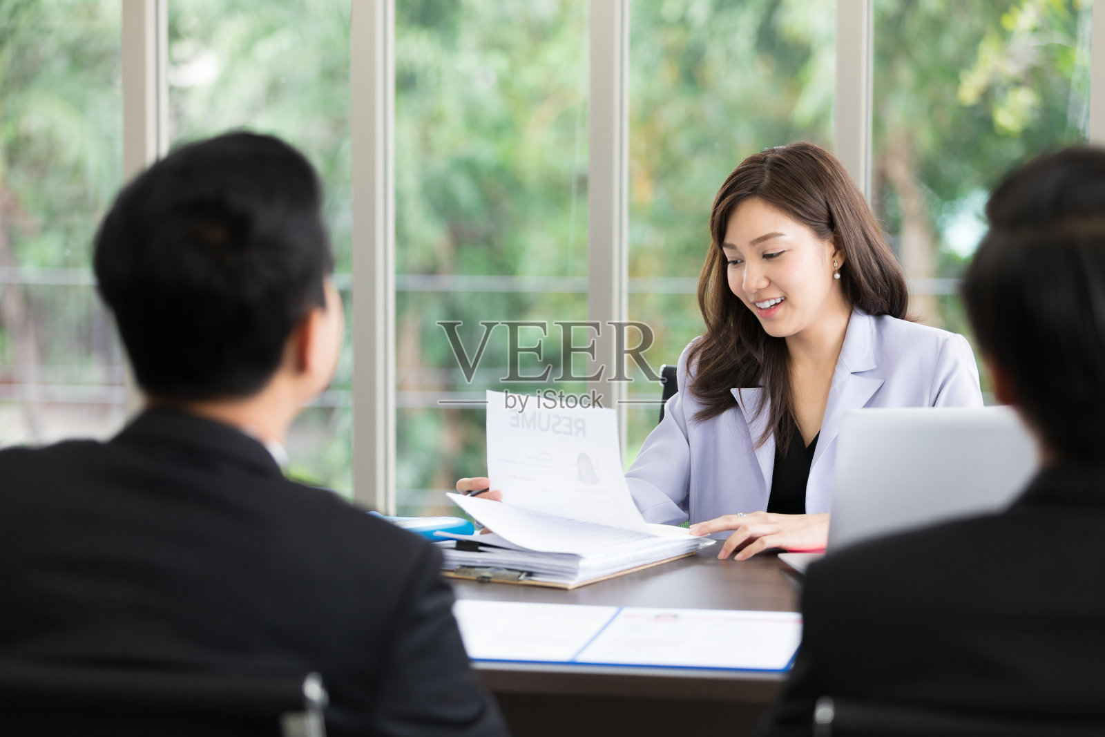 亚洲女性人力资源官员持有简历的工作面试，考虑男性员工候选人的空缺工作职位照片摄影图片