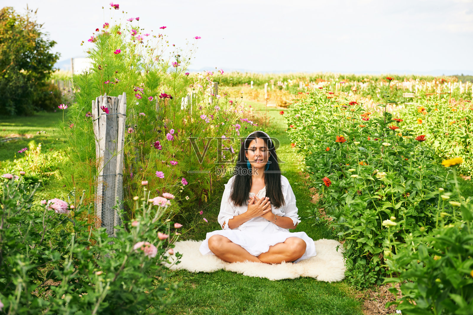中年妇女在绿色花园沉思，手放在心上，闭上眼睛照片摄影图片