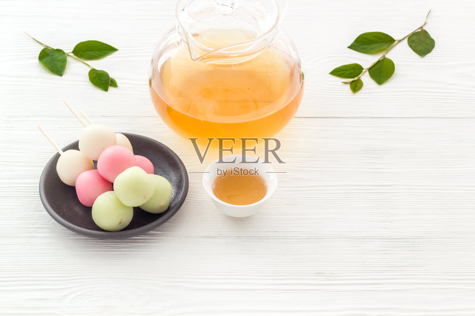 以甜食和茶为背景的日本食物。三种颜色的饺子照片摄影图片