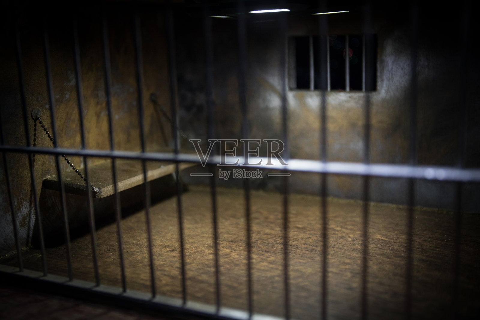 监狱或牢房。老式的垃圾监狱迷你版。黑暗监狱内部创意装修。空细胞。选择焦点过时的灰色垃圾混凝土房间。照片摄影图片