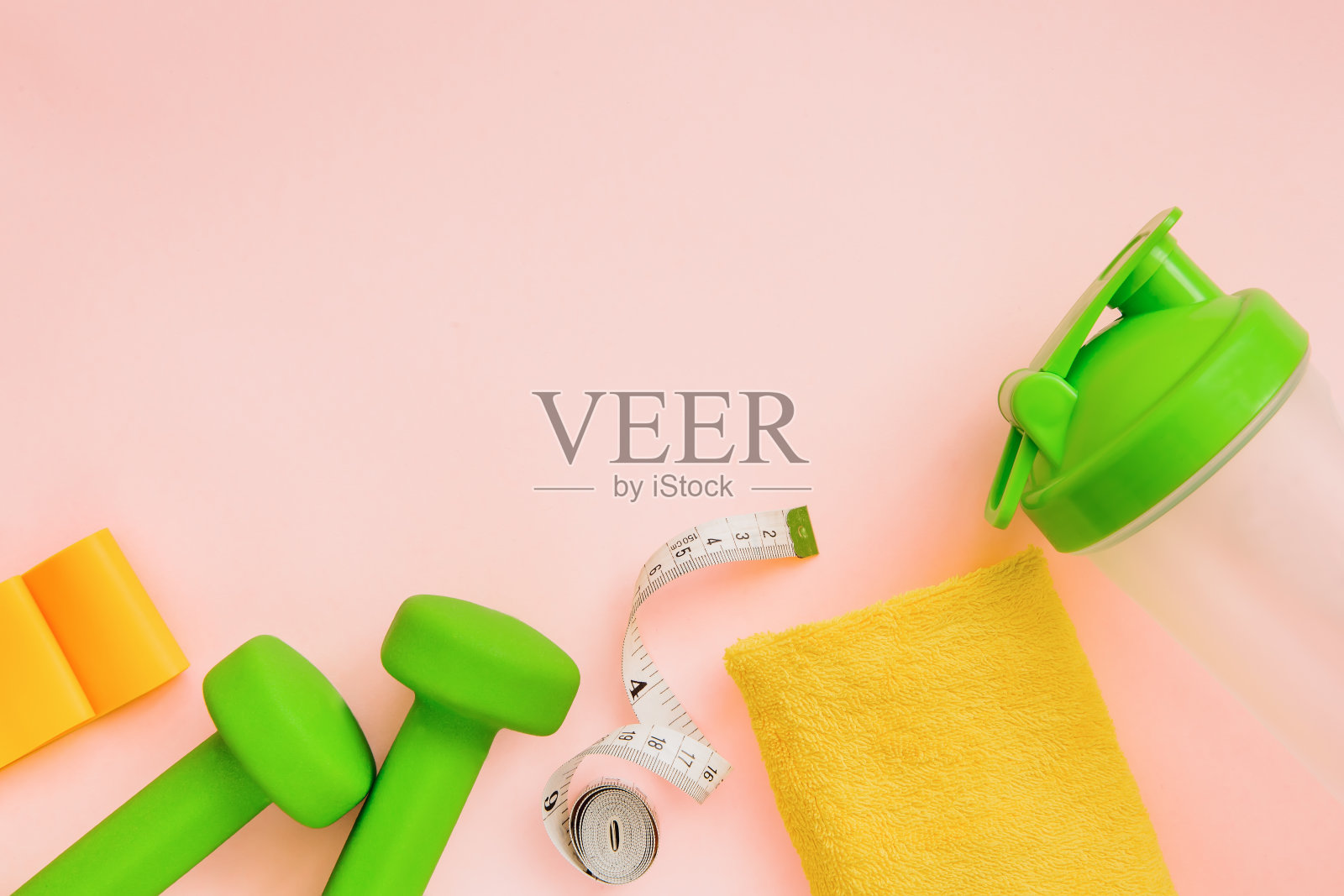 健身概念与哑铃，毛巾，水瓶在粉红色的背景。健康的生活方式，减肥。文本。照片摄影图片